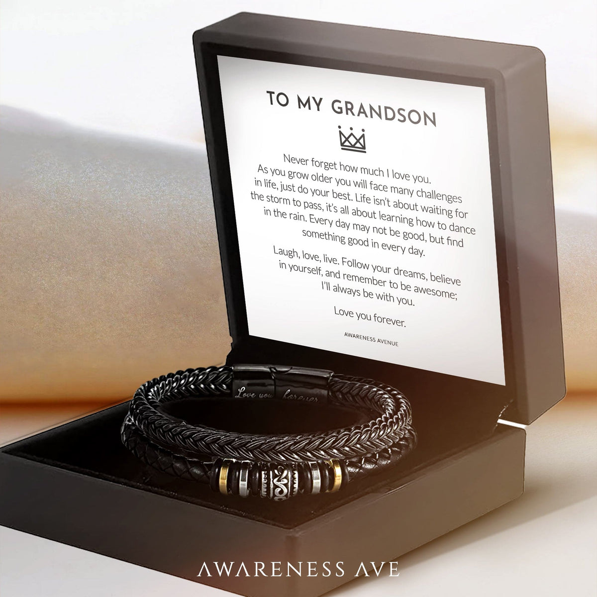 Black braided bracelet with metal-toned accents in an open box and a message card.