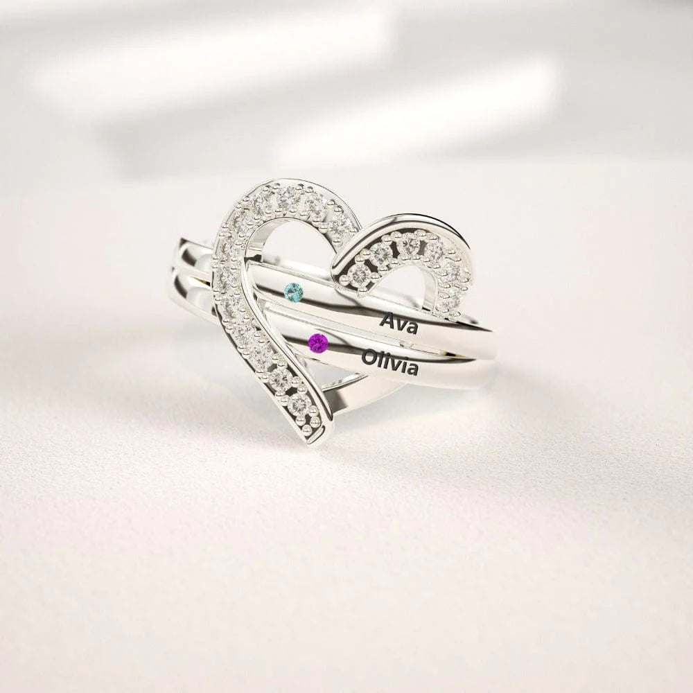 Silver-toned heart-shaped ring with three stacked bands, engraved with two names and two small blue and purple accents.