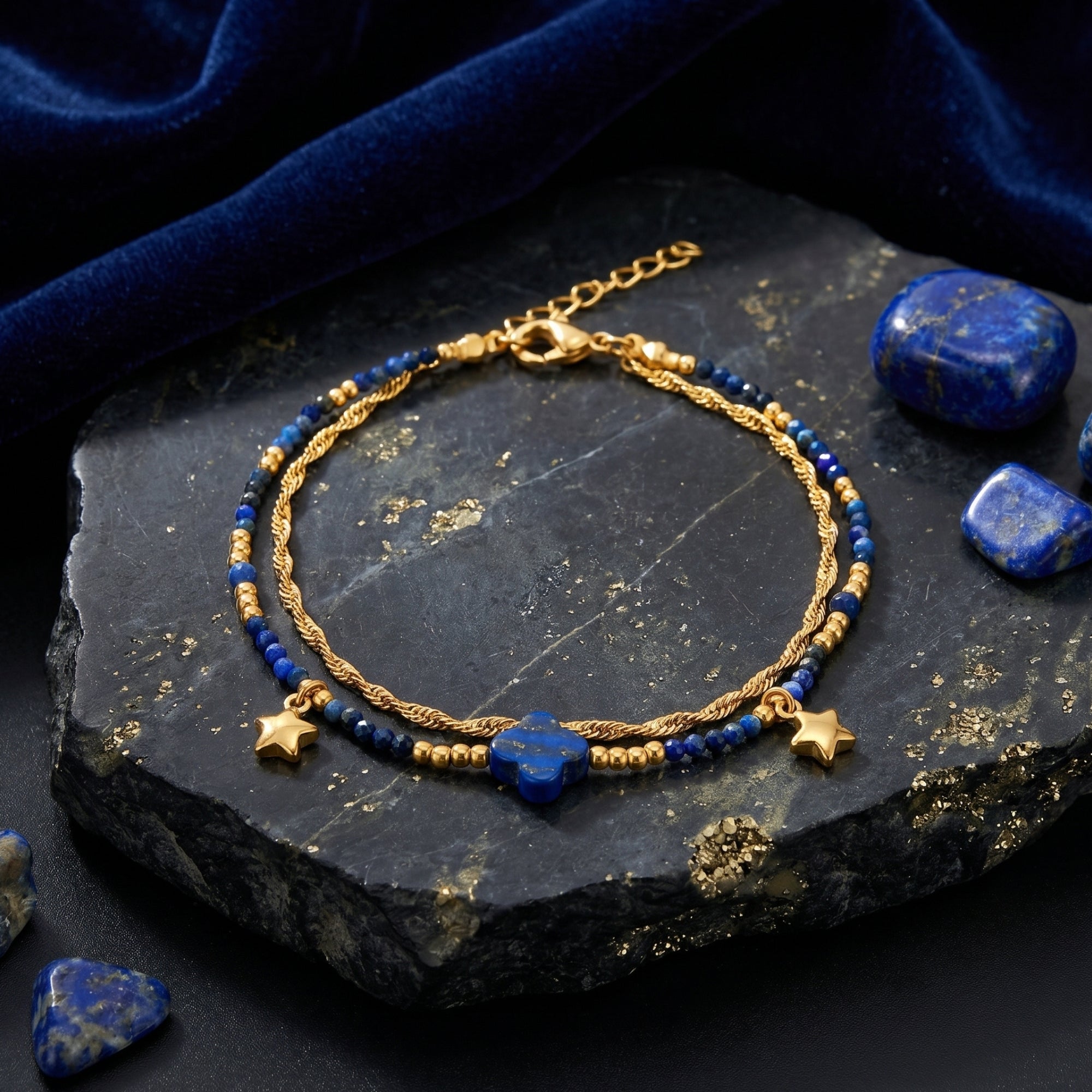 18K gold plated stainless steel bracelet with 3mm natural lapis beads and clover-shaped stone on a dark stone.