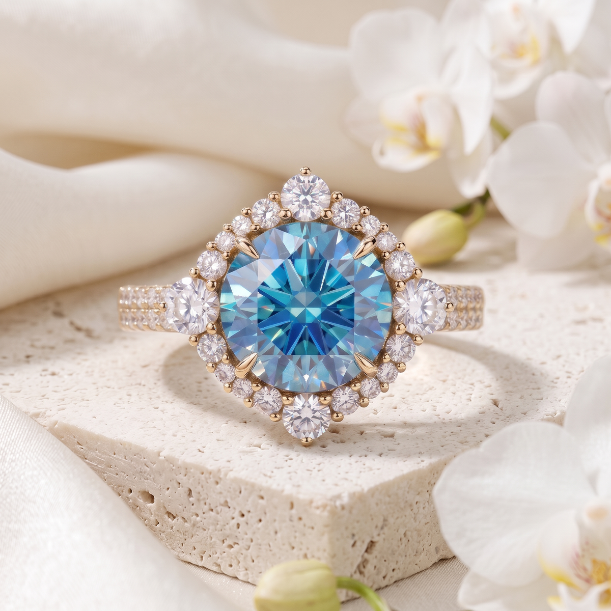Round blue moissanite engagement ring with geometric diamond halo in yellow gold on stone display