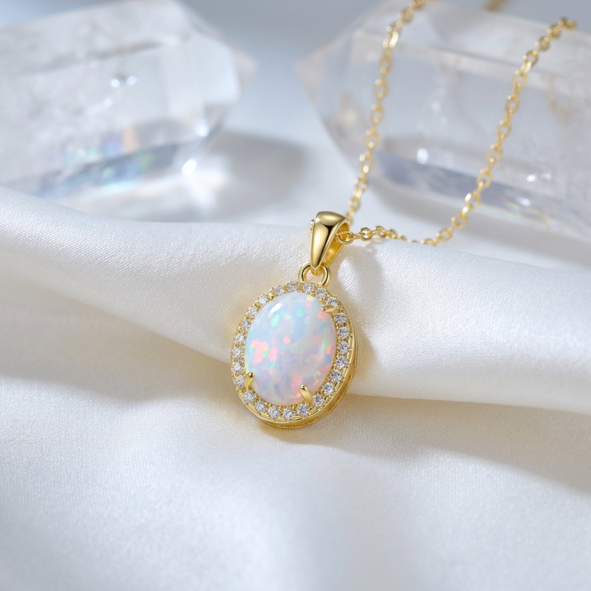 Gold-tone S925 silver necklace with an oval cut white opal pendant, styled on white silk with quartz crystals.