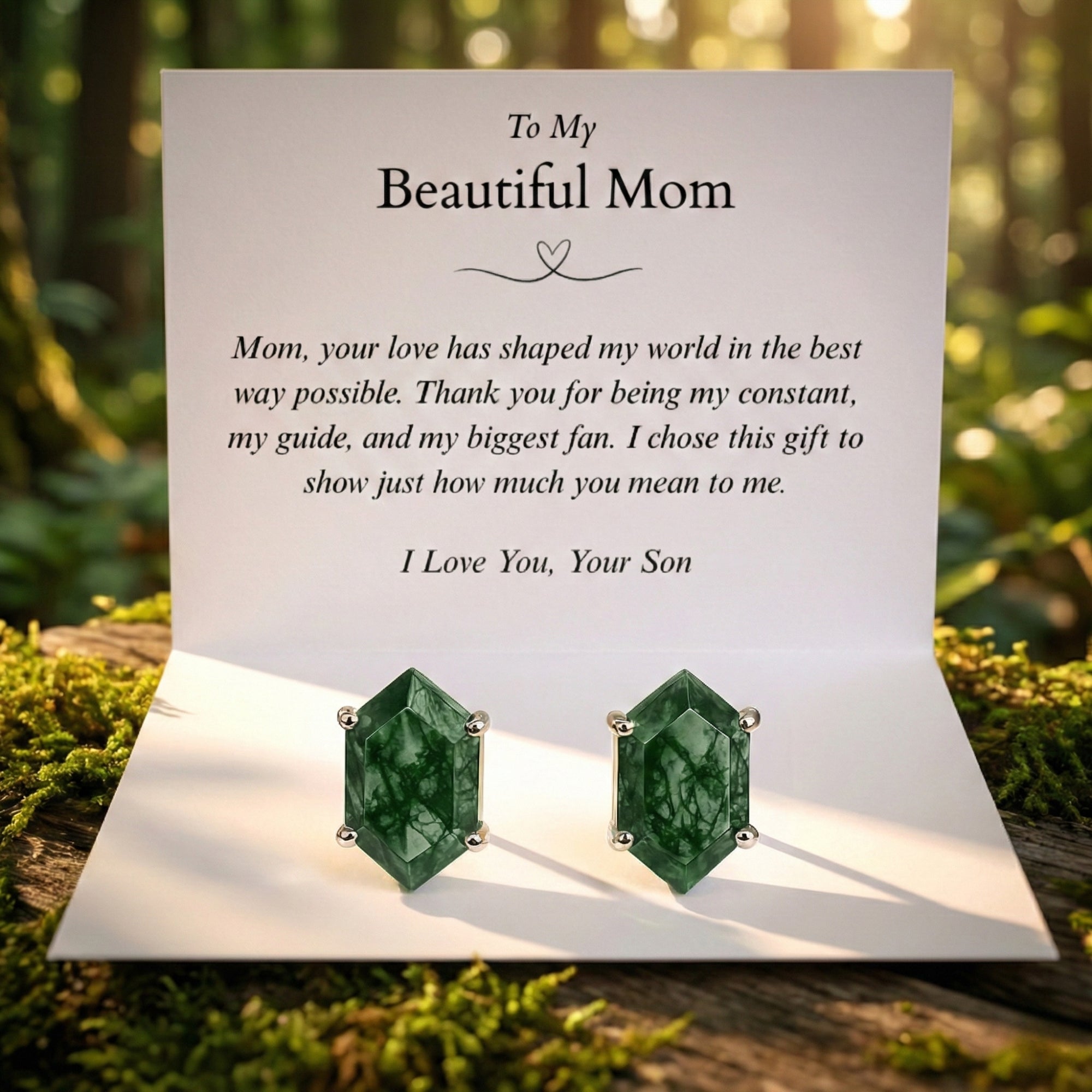 Hexagon-cut moss agate stud earrings in sterling silver on a white message card for mom in a forest setting.