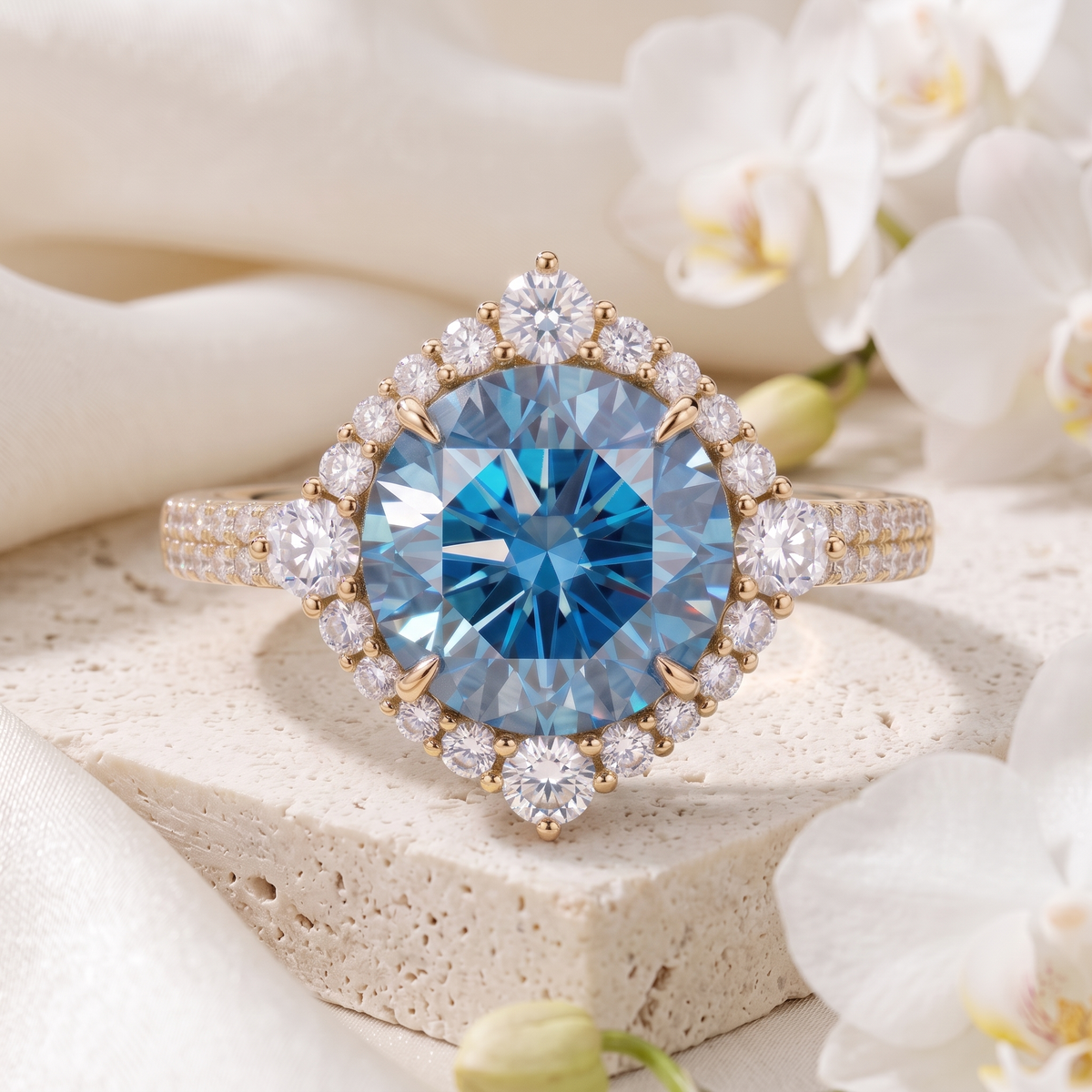 Round blue moissanite halo engagement ring in yellow gold on a stone display.