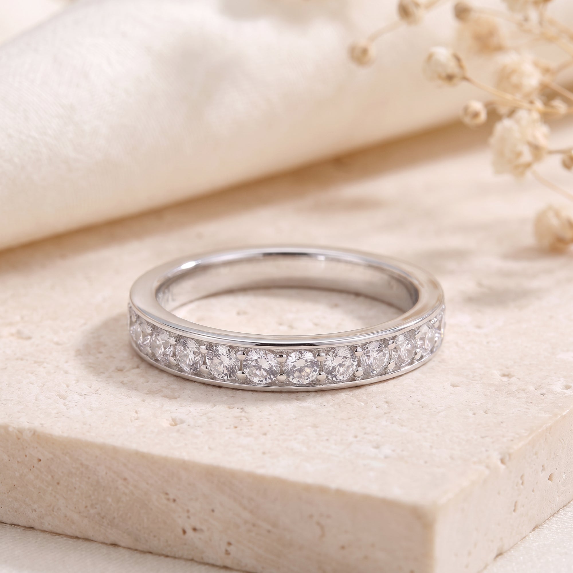 S925 silver eternity ring with round cubic zirconia in channel setting on stone.