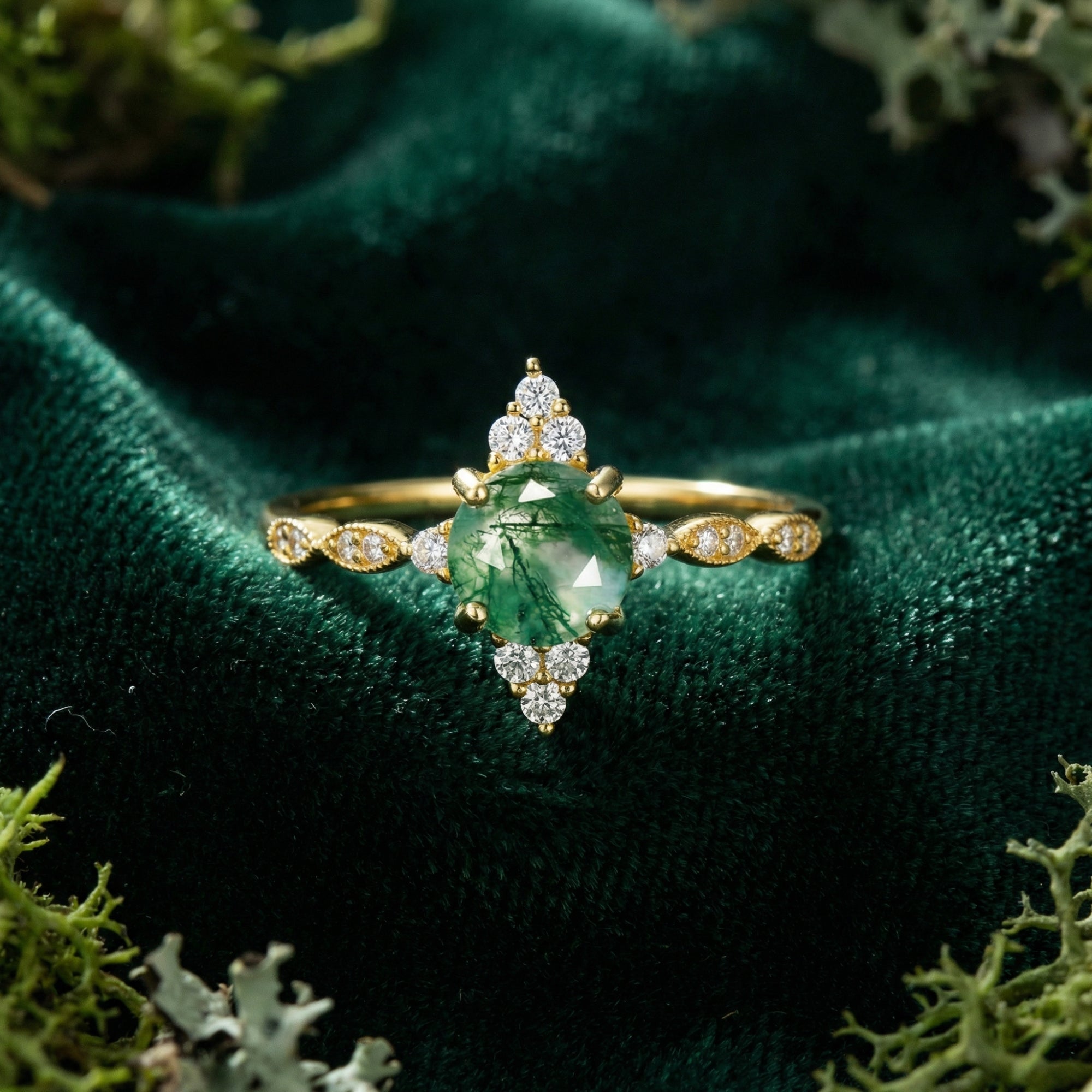 Gold S925 sterling silver ring featuring a round moss agate stone in a sunburst setting on green velvet.