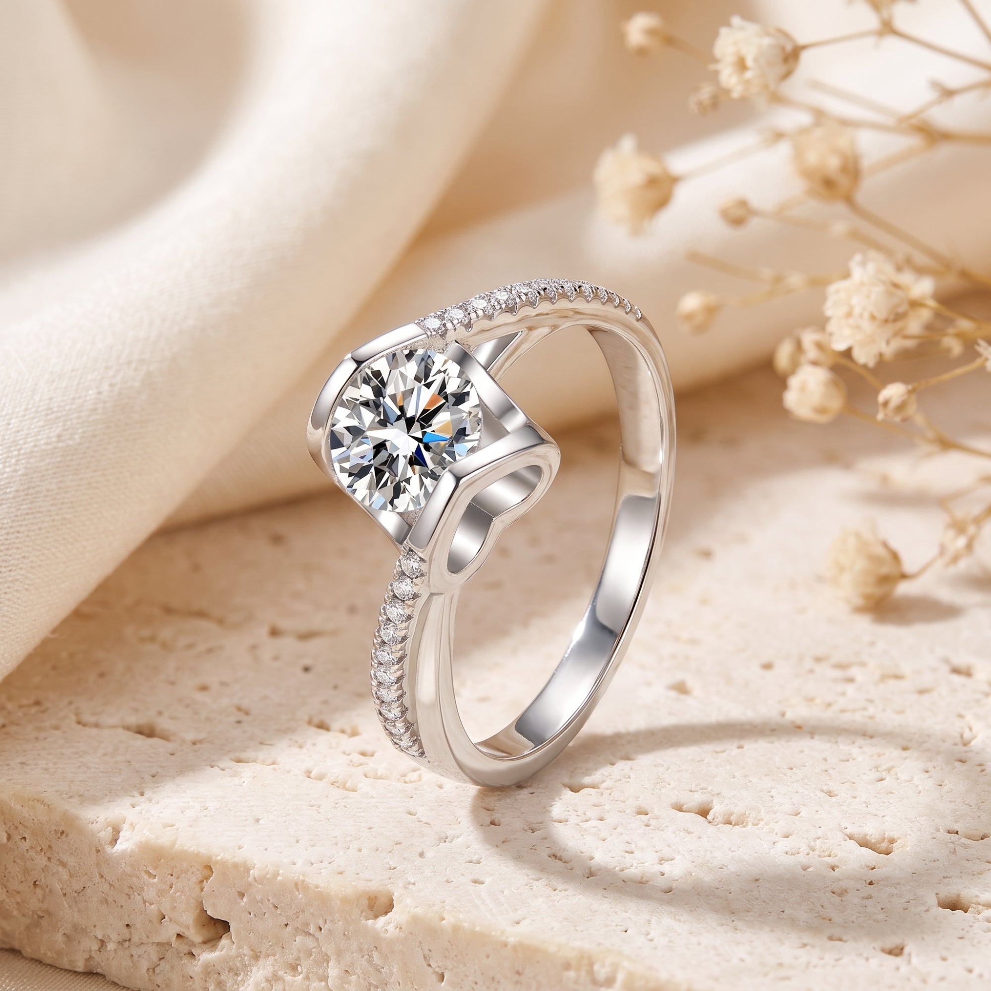 Round-cut cubic zirconia solitaire ring with bypass arms in S925 sterling silver on a lifestyle stone background.