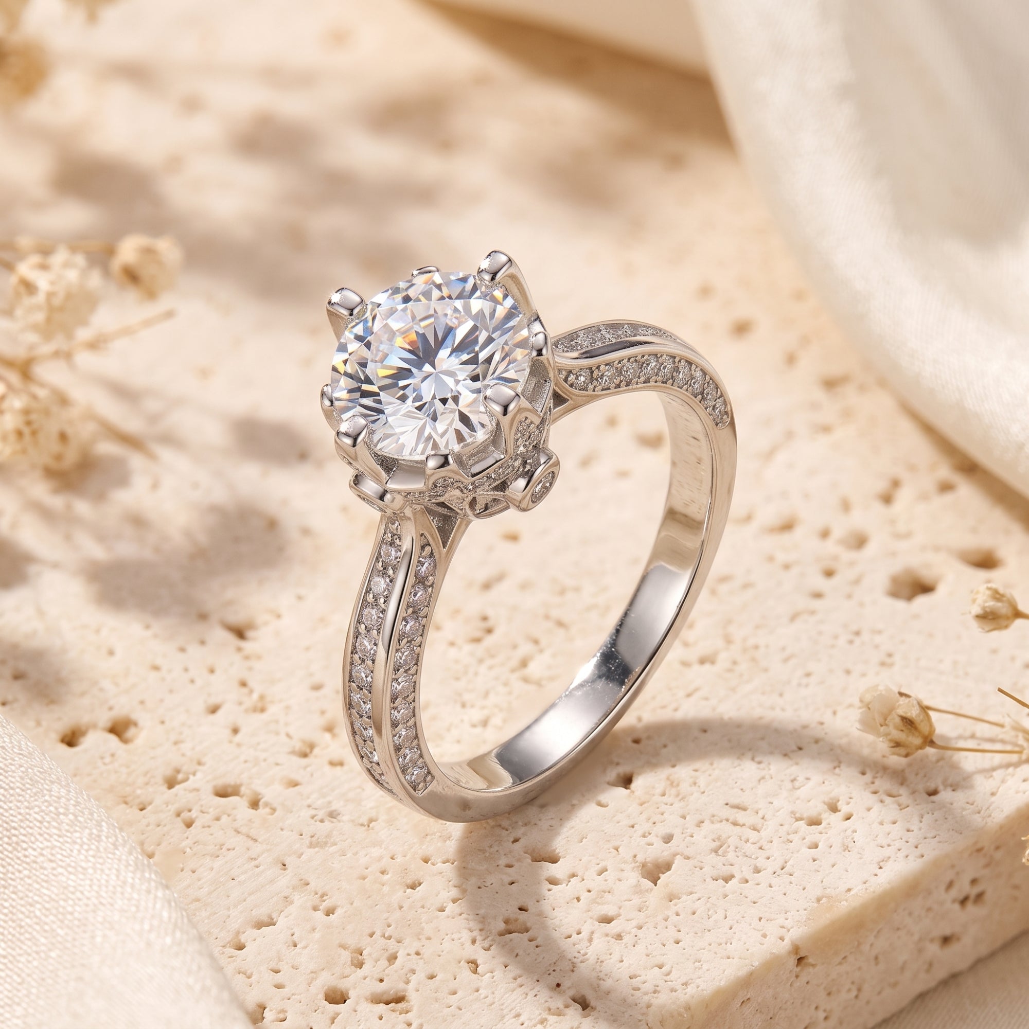 Sterling silver crown cathedral ring with a round brilliant stone on a textured stone and fabric background.