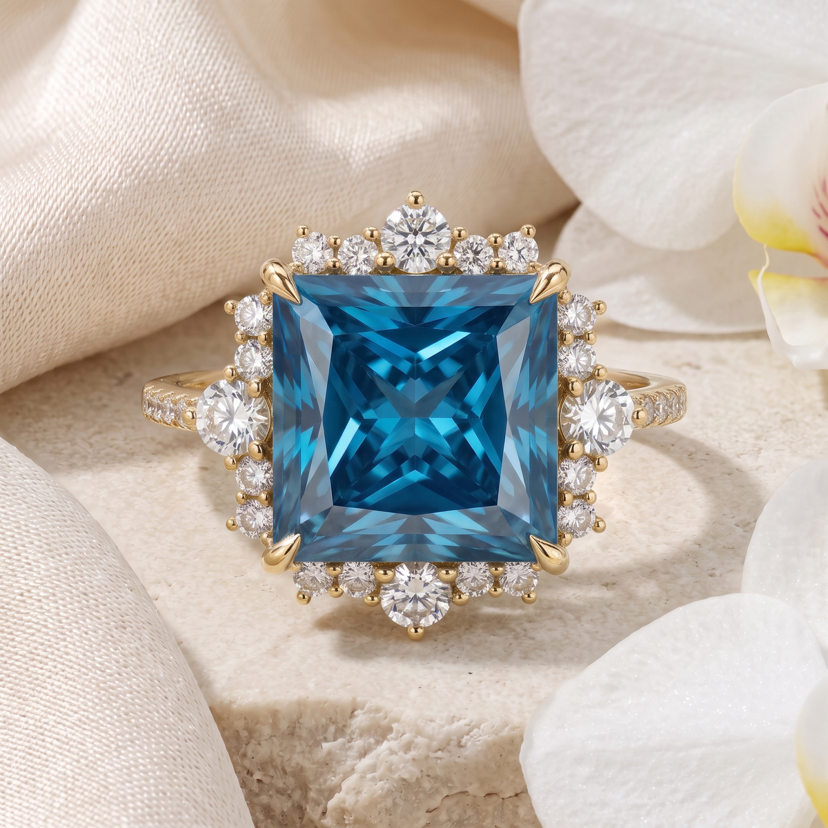 Front view of a yellow gold princess-cut blue moissanite halo engagement ring on textured stone.