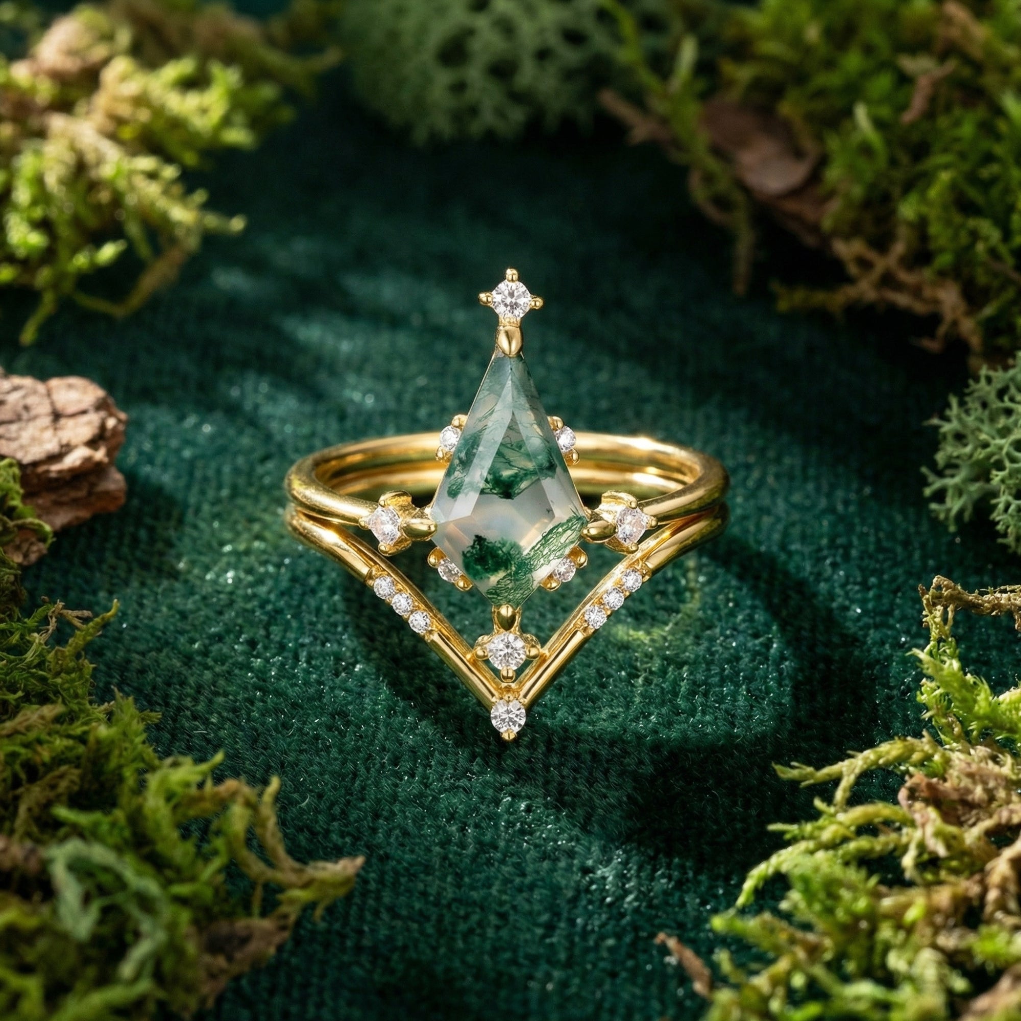 Kite cut natural moss agate gold ring set centered on a lush green moss background.