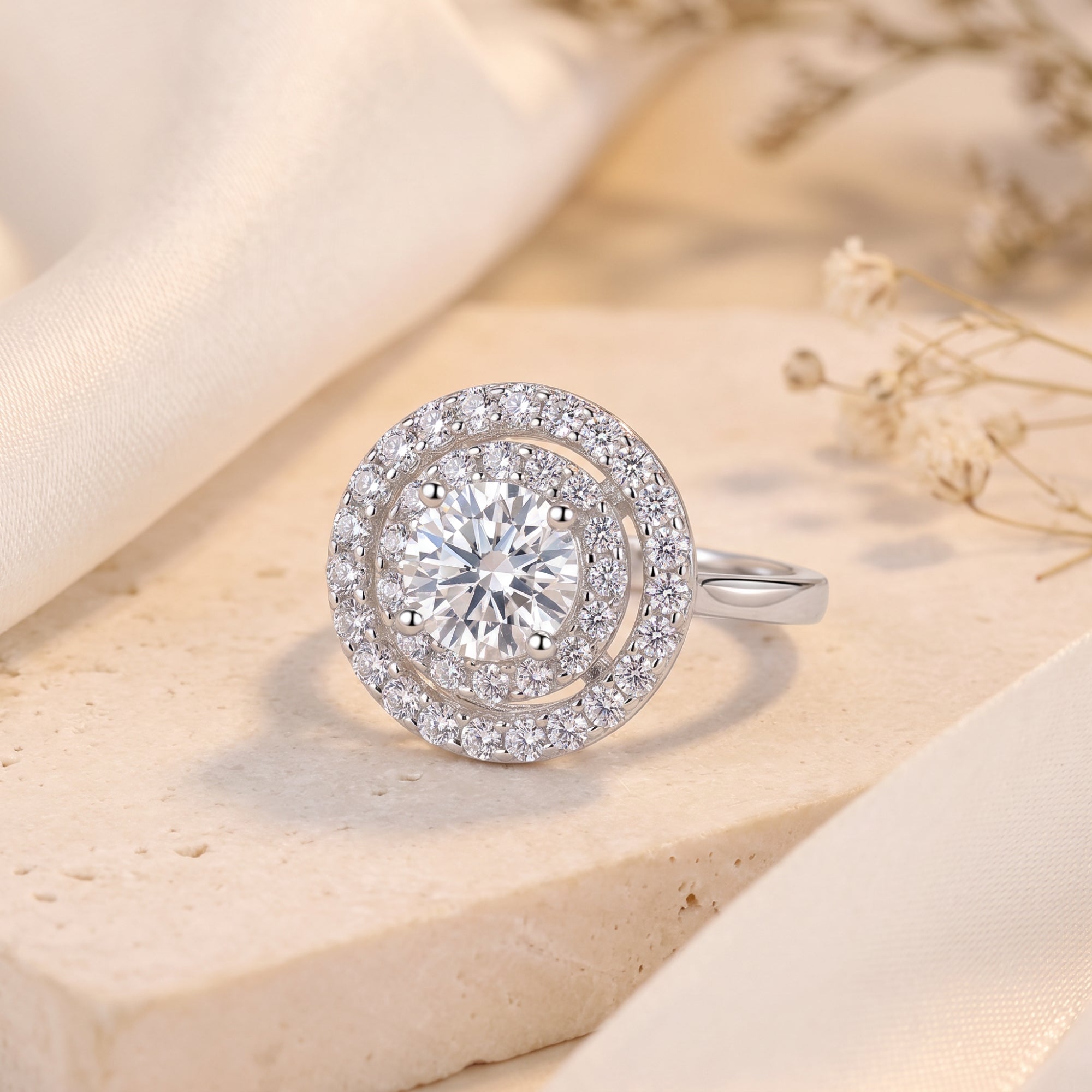 Round cut simulated diamond double halo ring in S925 sterling silver on a stone surface.