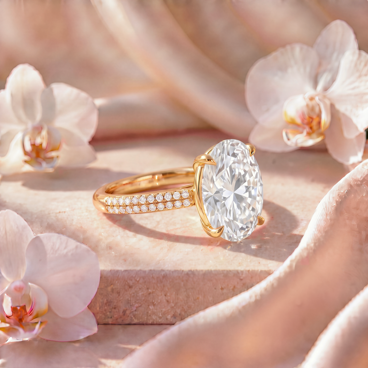 Side angle view of an oval moissanite engagement ring with a double-row pavé band in yellow gold.