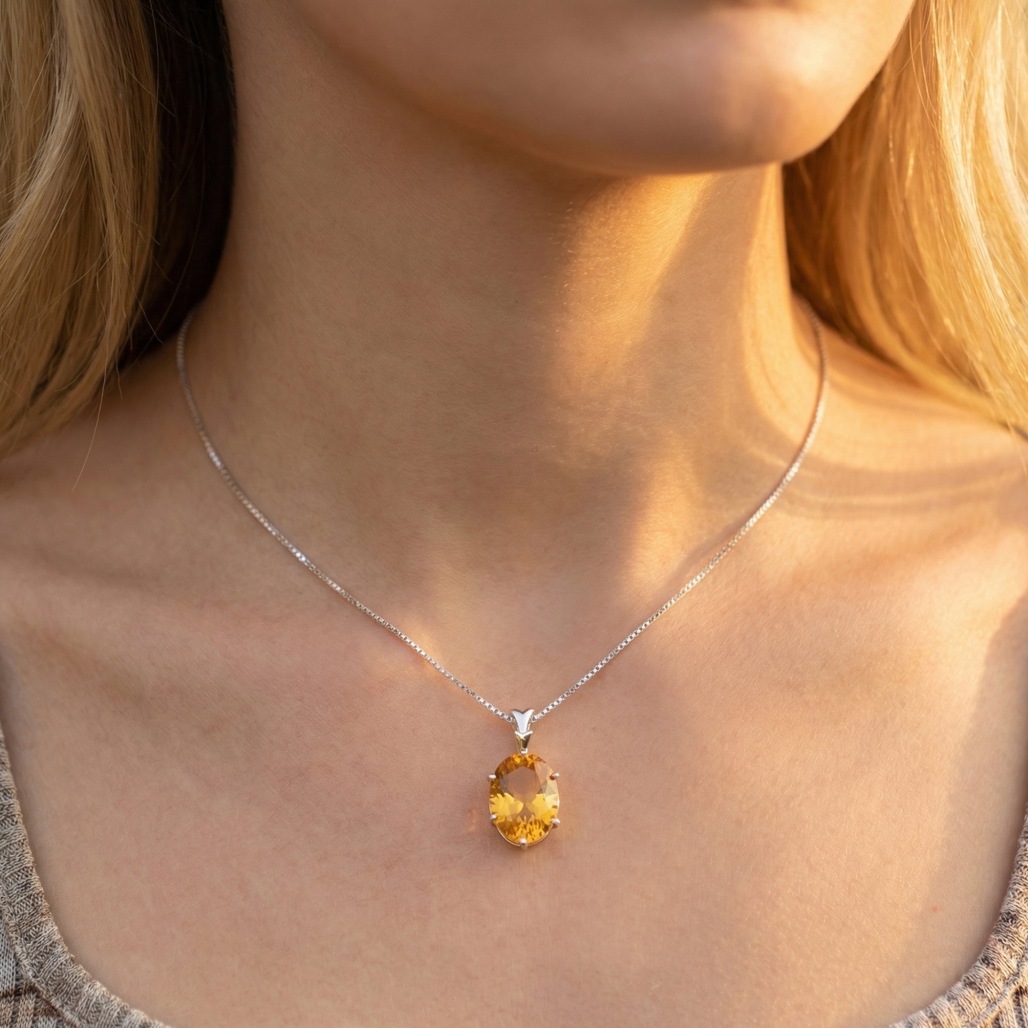 Model wearing the Sunfire oval natural citrine necklace in silver, showcasing the pendant's scale on the neck.
