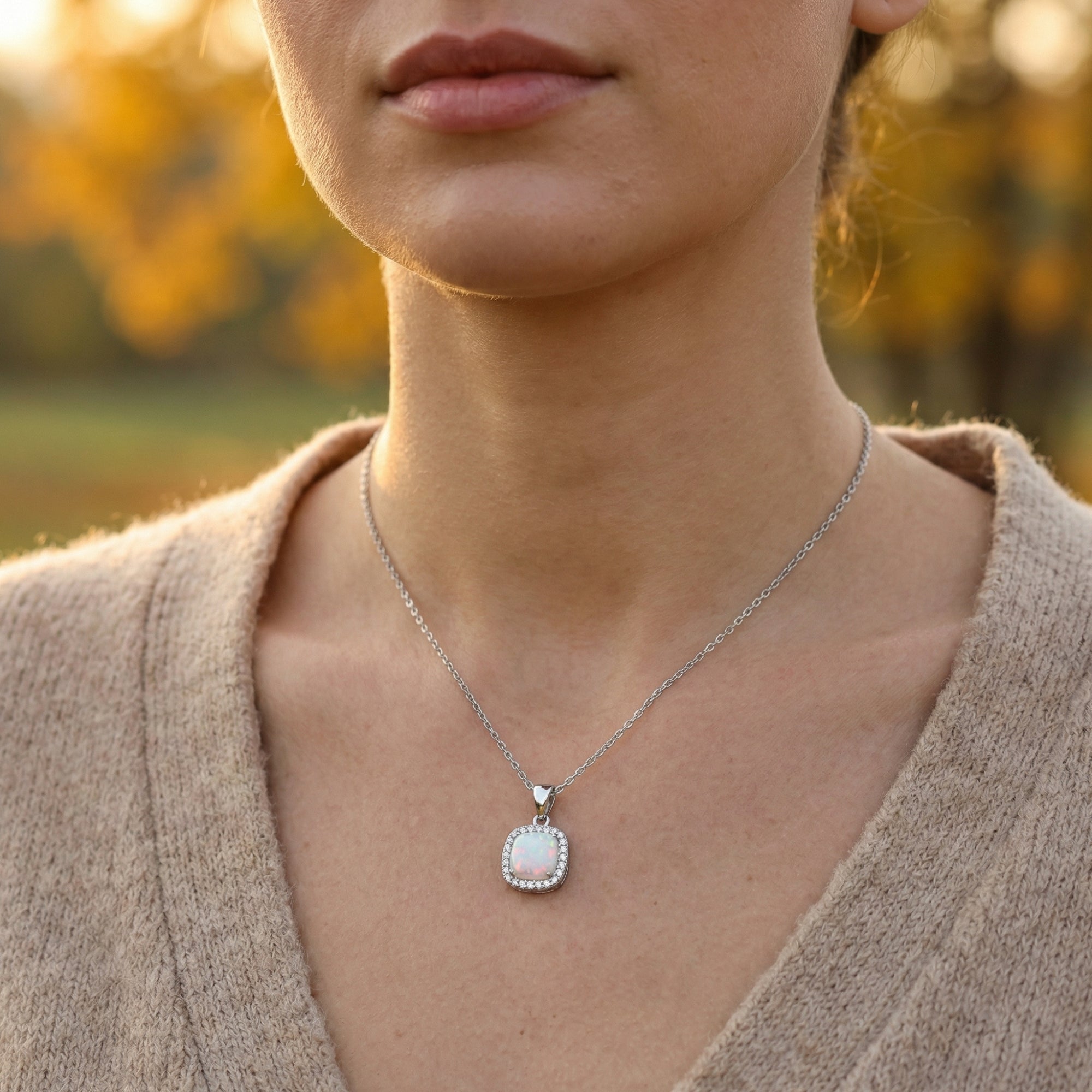 Woman wearing the silver cushion cut white opal halo pendant necklace for a minimalist everyday look.