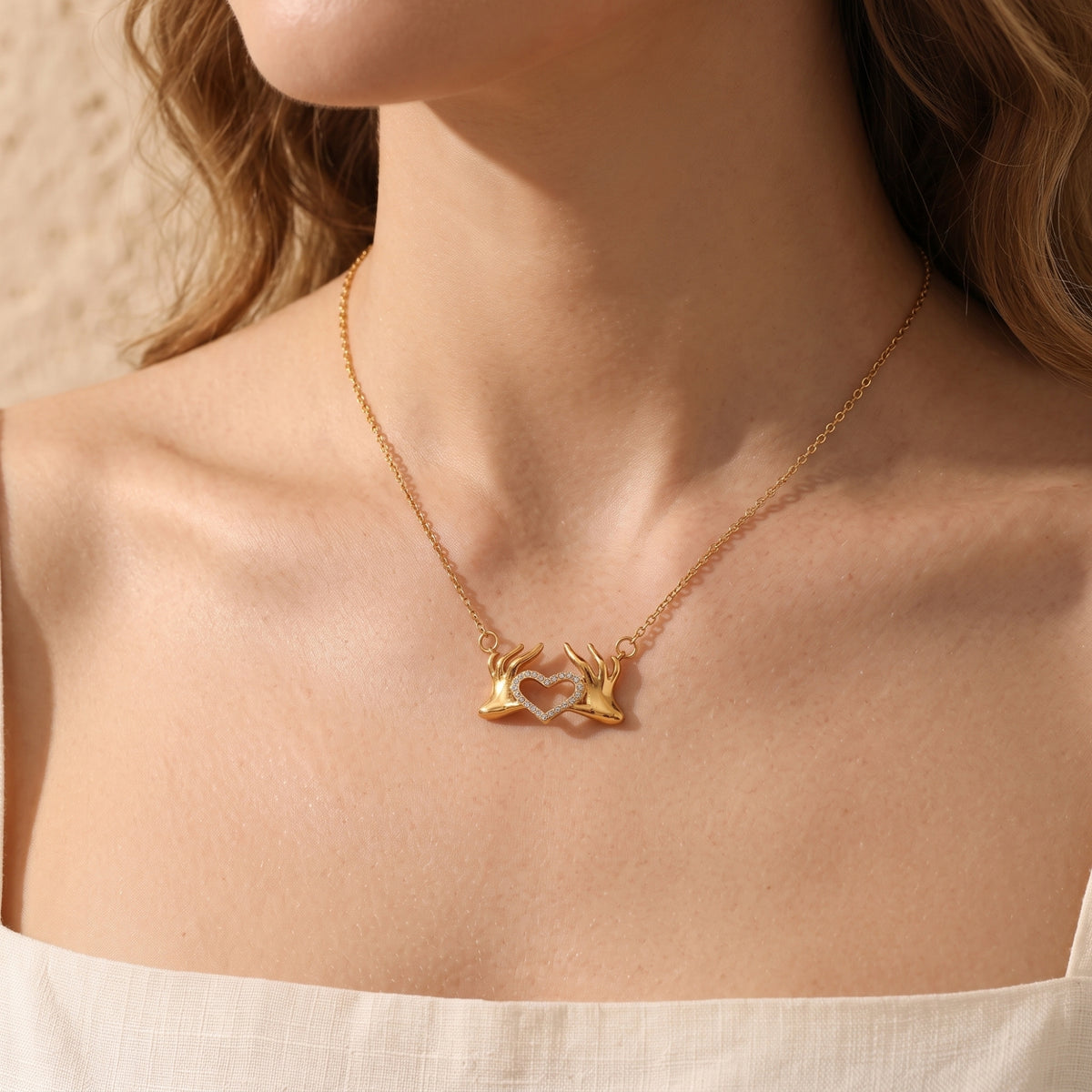Le collier pendentif mains formant un cœur