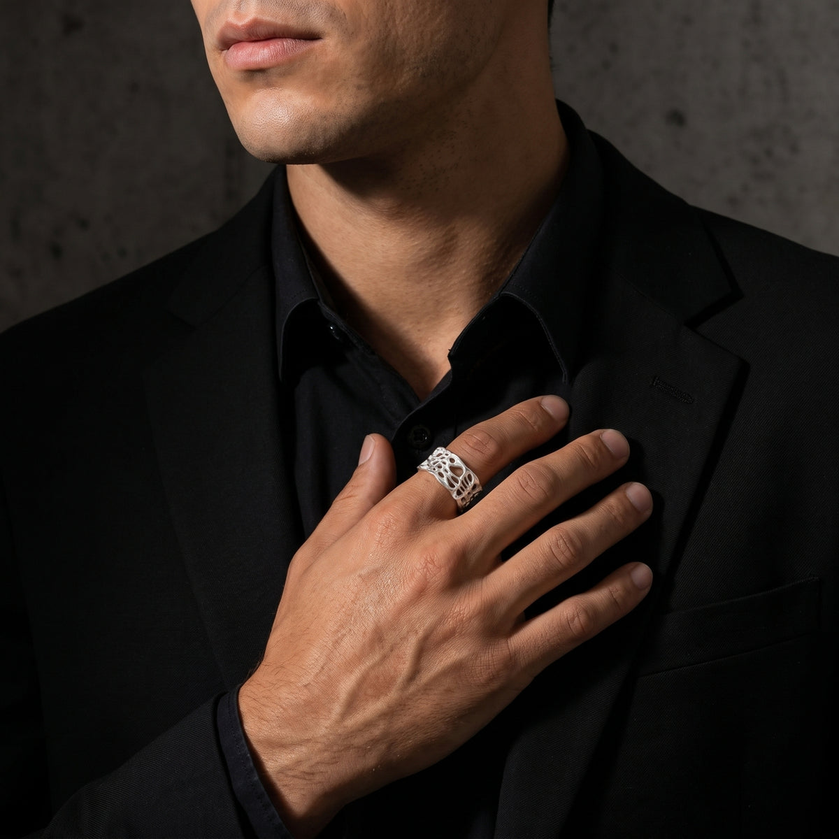Person wearing the fine-silver open band ring on the ring finger over a black jacket.
