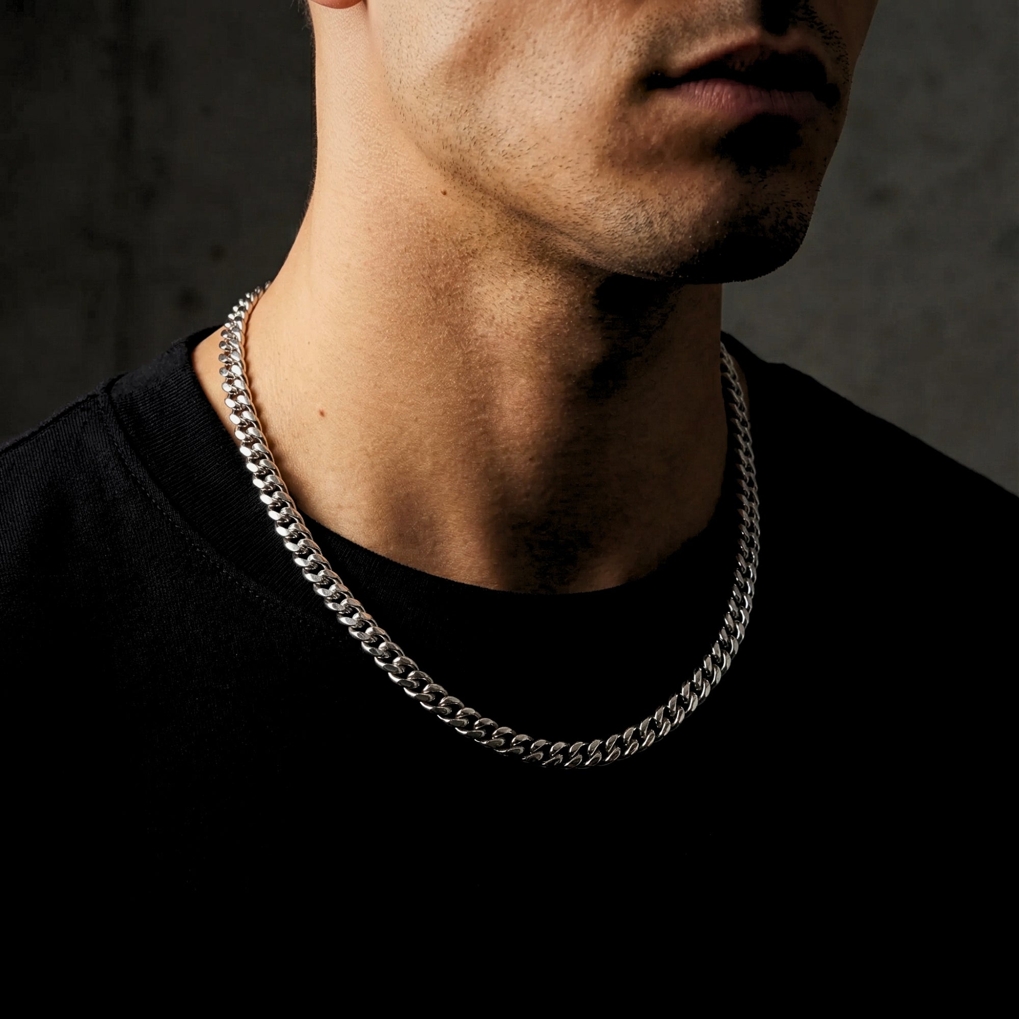 Male model wearing the 8mm silver stainless steel Titan Cuban chain necklace over a black shirt.