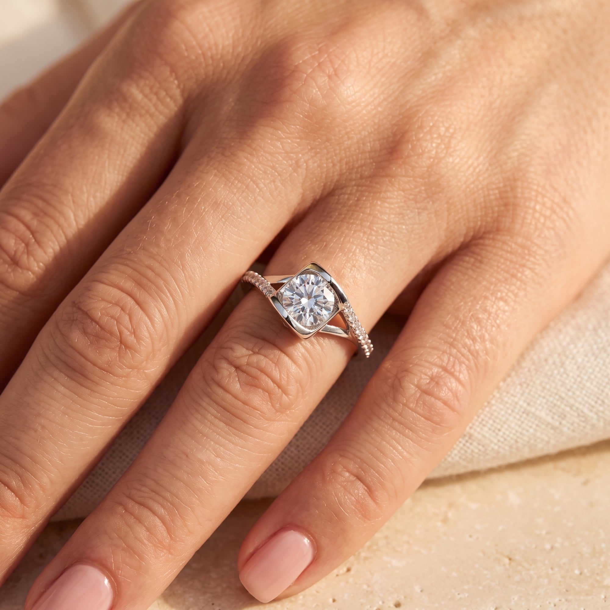 Top view of the round-cut simulated diamond solitaire ring in sterling silver worn on a woman's finger.