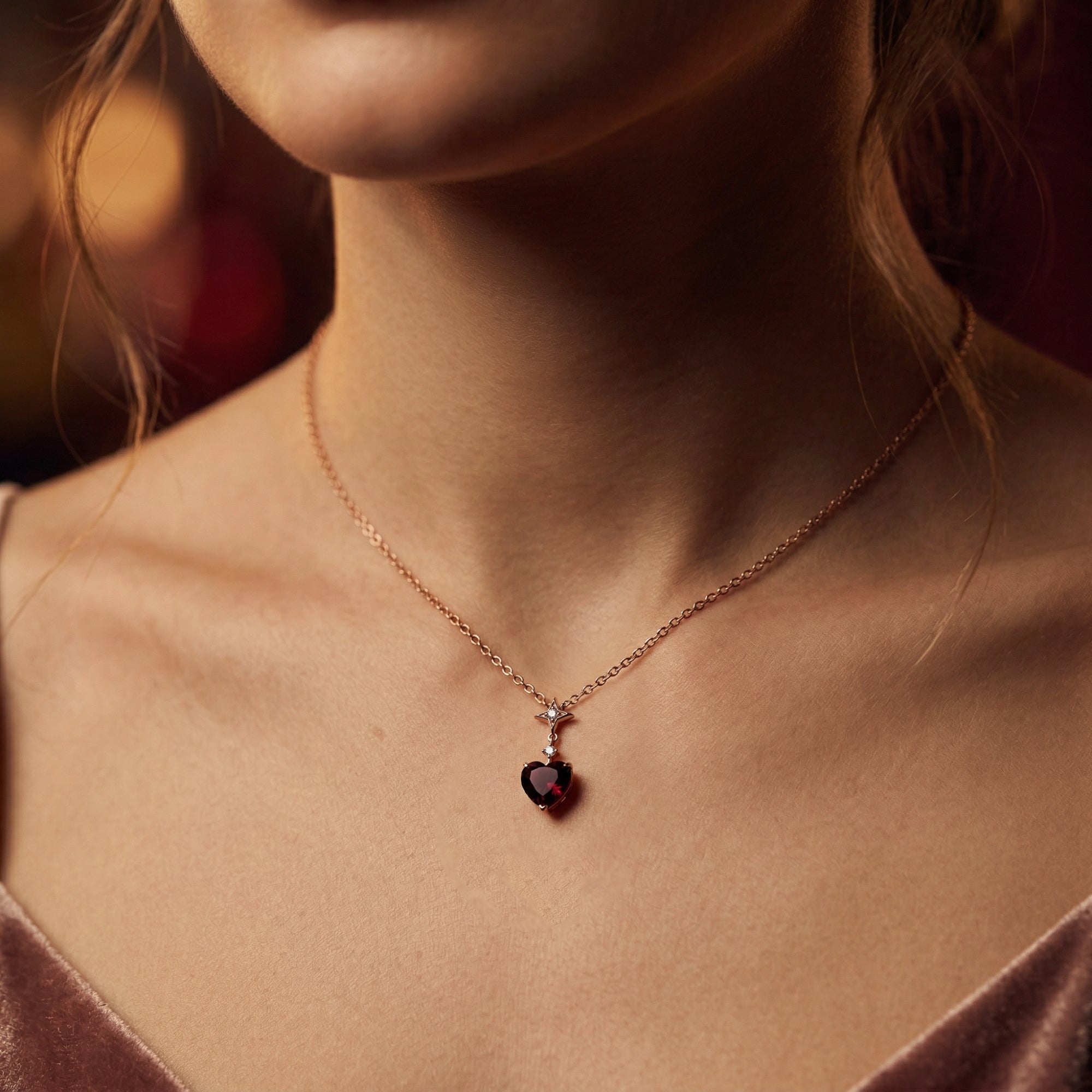Model wearing the Carmine Heart necklace in 18K rose gold featuring a heart-cut natural red garnet.