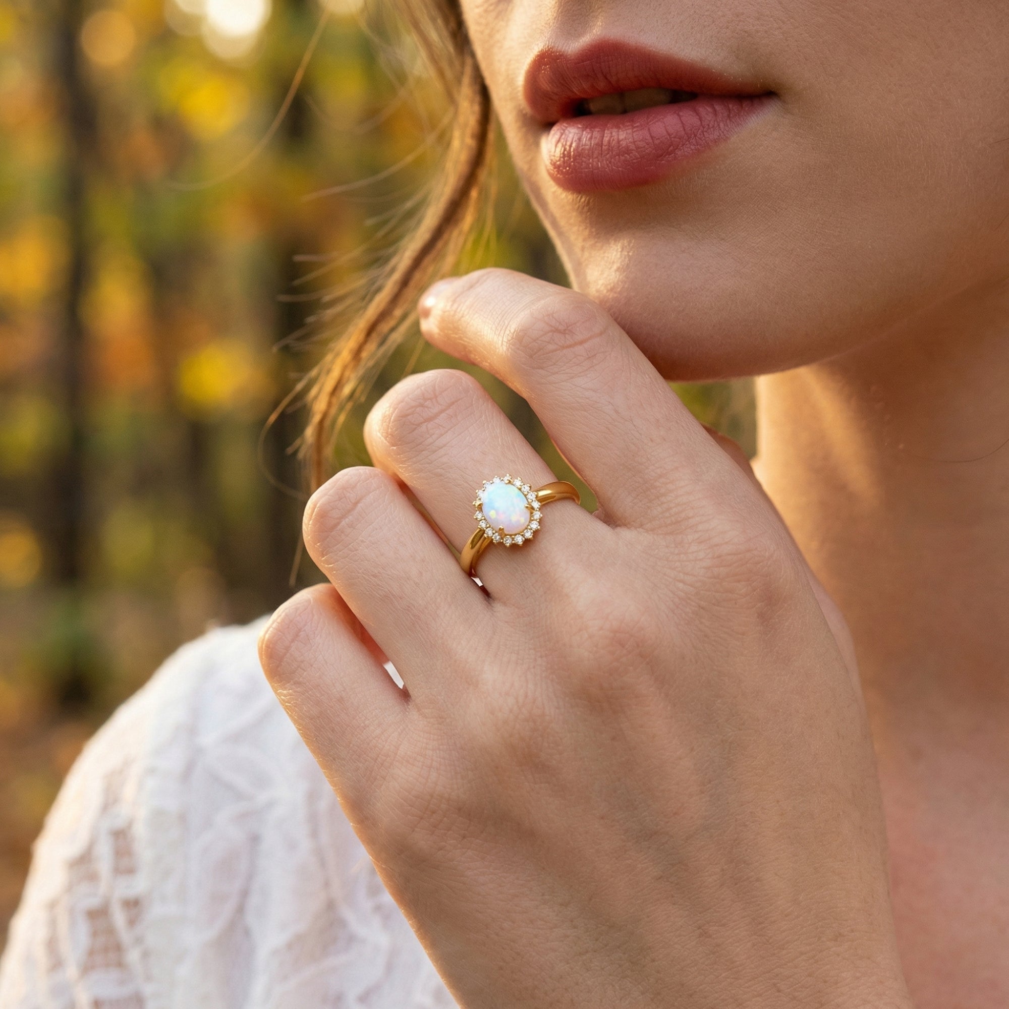 Woman wearing the gold-tone oval opal halo ring on her finger, showcasing the October birthstone jewelry.