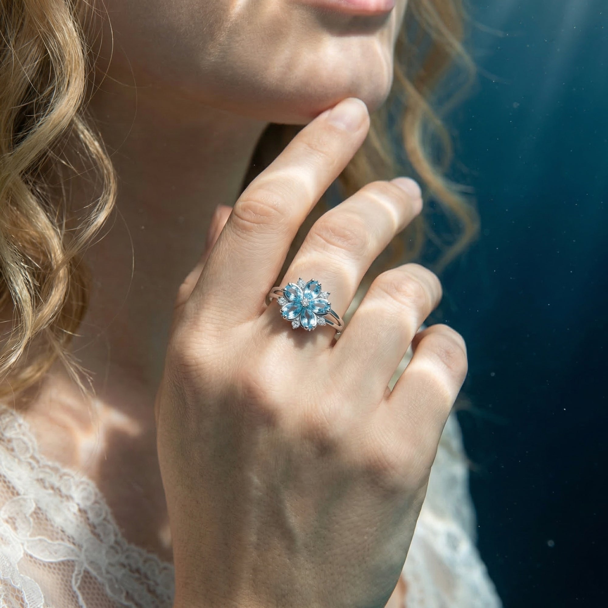 Woman wearing the Undine Blossom aquamarine floral ring in sterling silver on her finger.