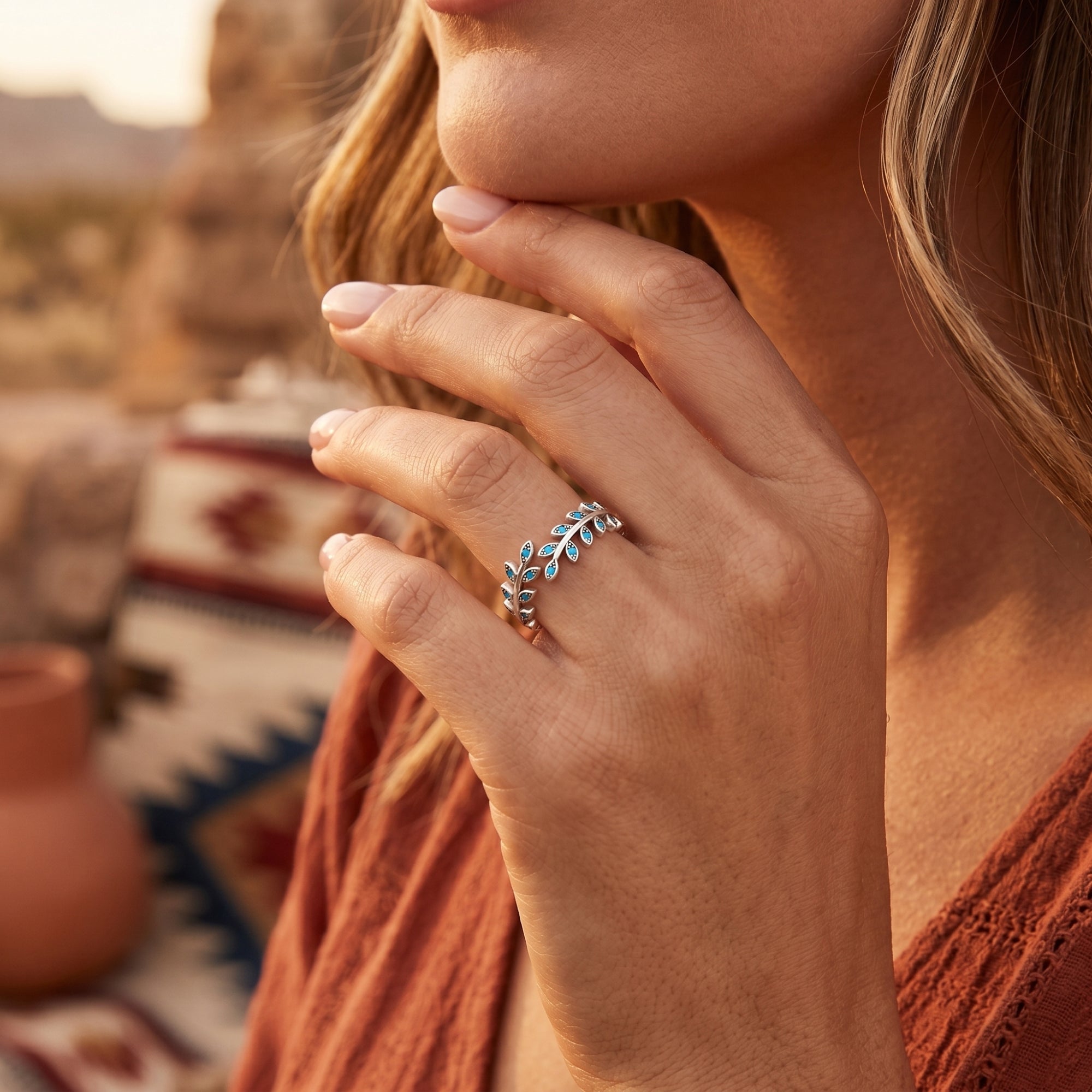 The Arroyo turquoise leaf ring in sterling silver worn on a woman's hand in a desert setting.