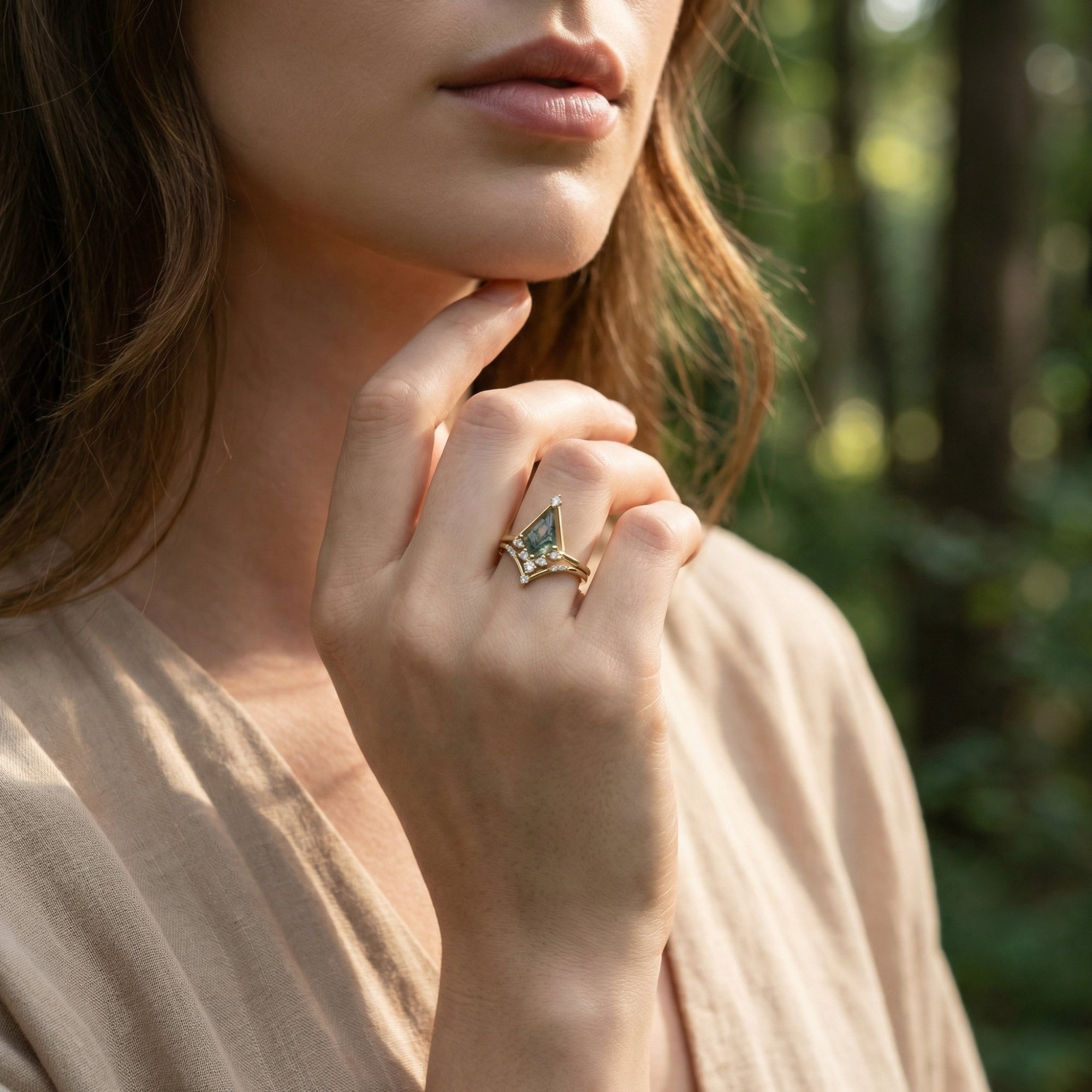 Model wearing the gold-plated moss agate pyramid ring set on her finger in a natural forest setting.