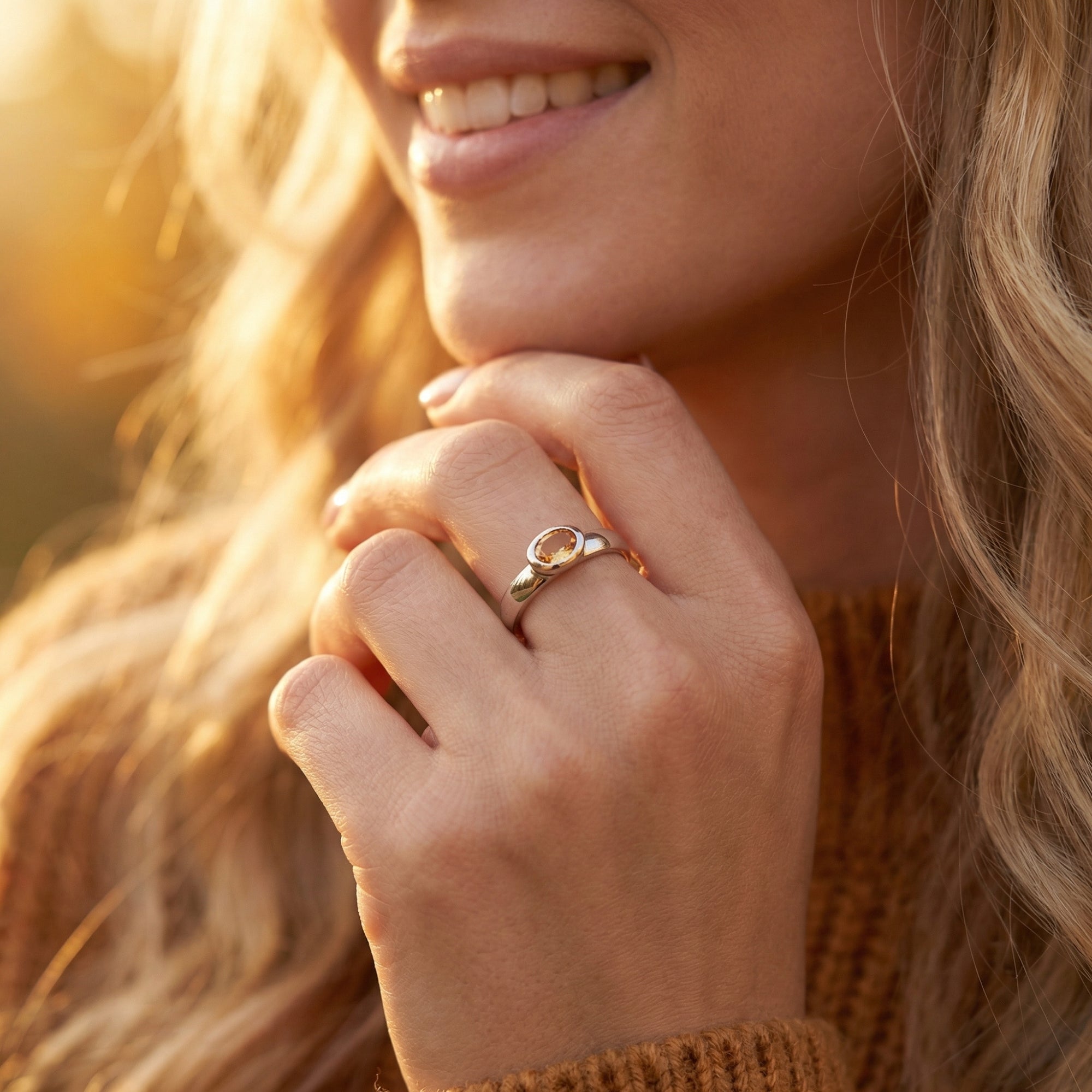Woman wearing the Marigold citrine ring in sterling silver on her finger in warm outdoor light.