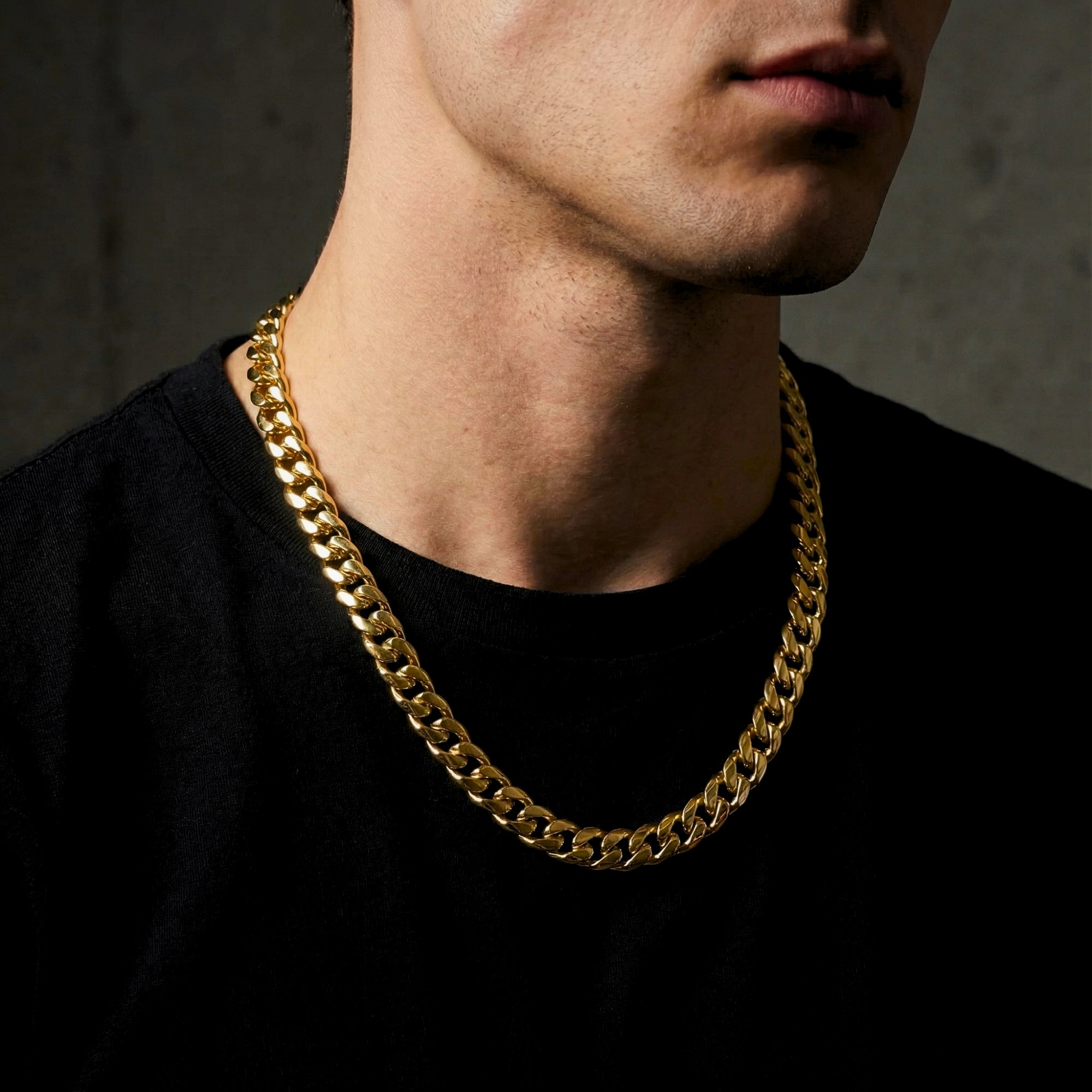 Male model wearing the 10mm gold Titan Cuban chain in stainless steel over a black t-shirt.
