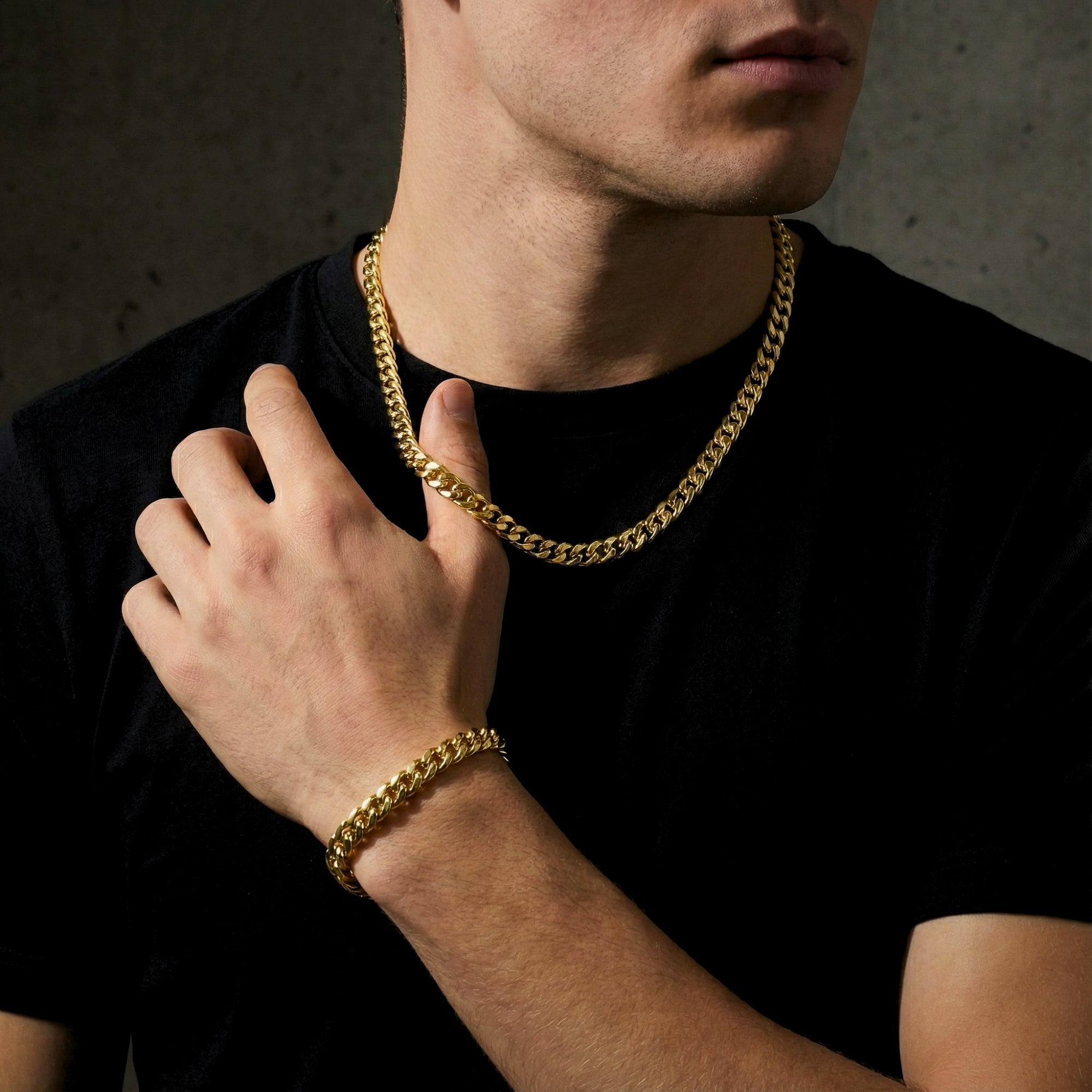 Man wearing the gold stainless steel 8mm Cuban link chain and matching bracelet with a black t-shirt.
