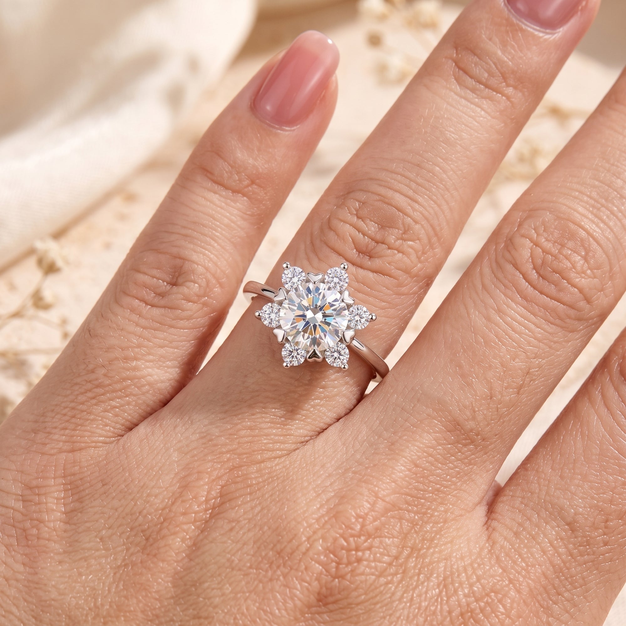 Silver snowflake promise ring with brilliant simulated diamonds worn on a woman's finger.