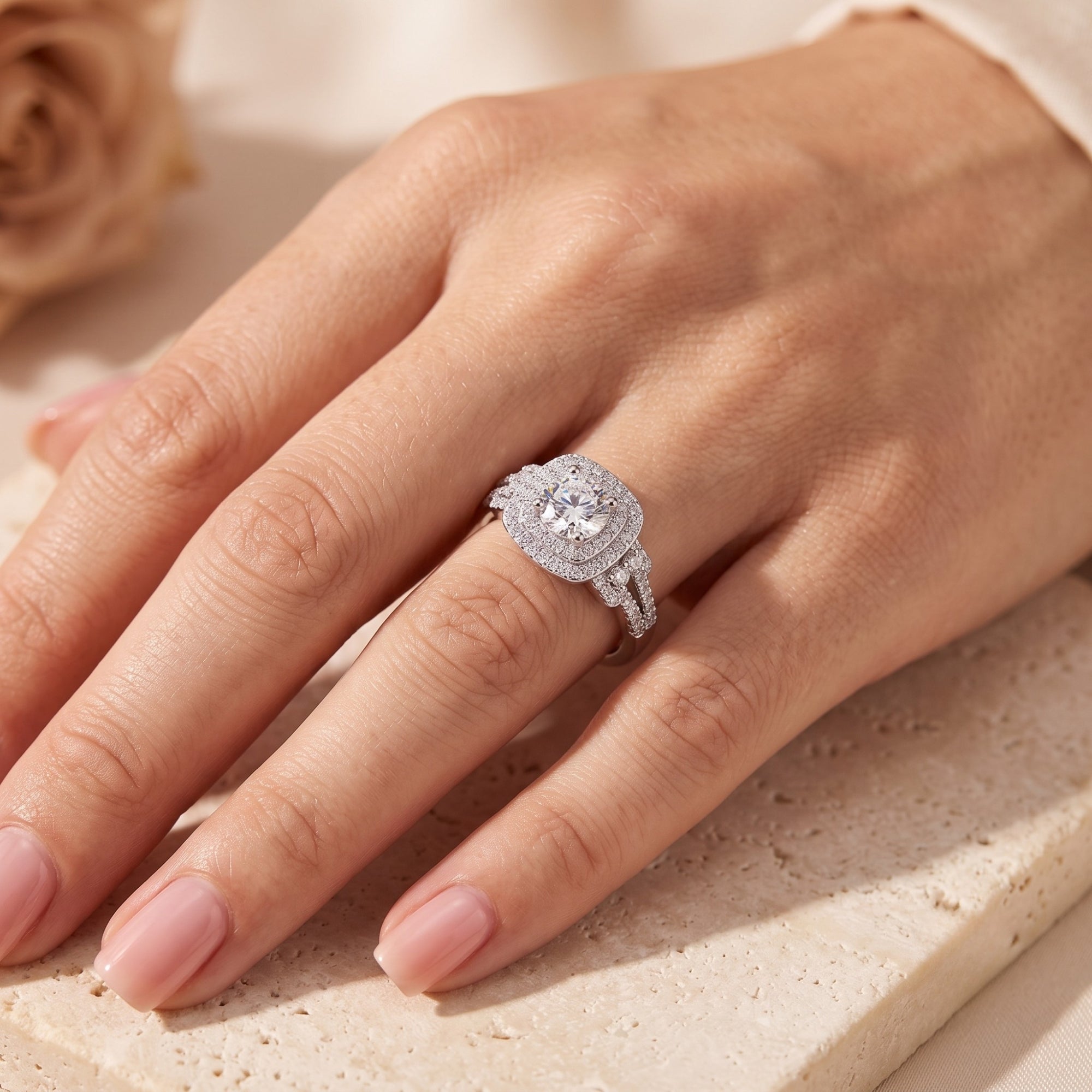 Sterling silver cushion double halo promise ring worn on a hand.