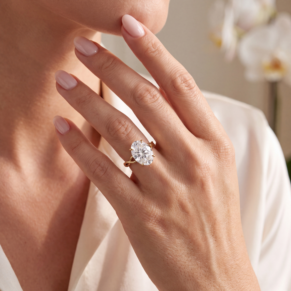 Woman wearing an oval moissanite engagement ring in gold on her hand.