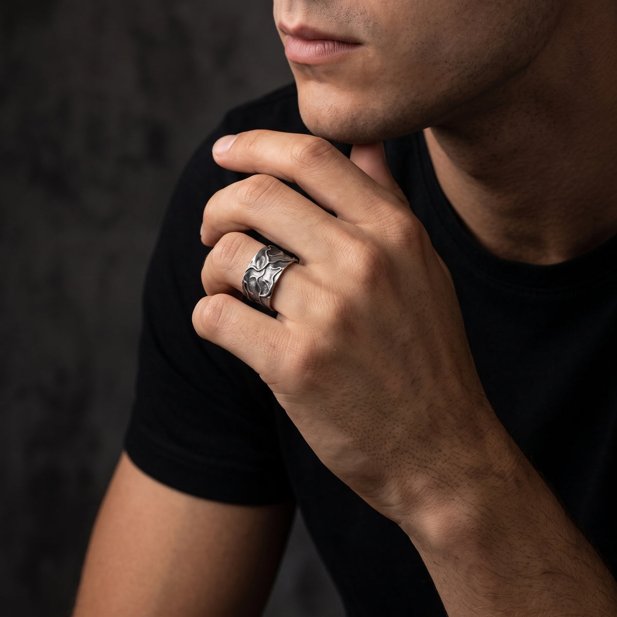 Model wearing the textured silver open band ring while resting his hand near his chin.