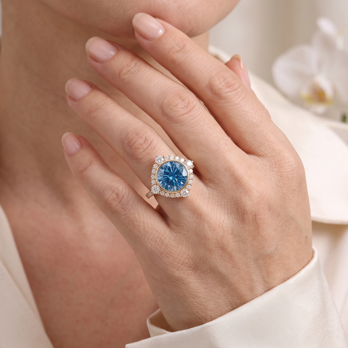 Round cut blue moissanite statement ring in rose gold worn on a hand.