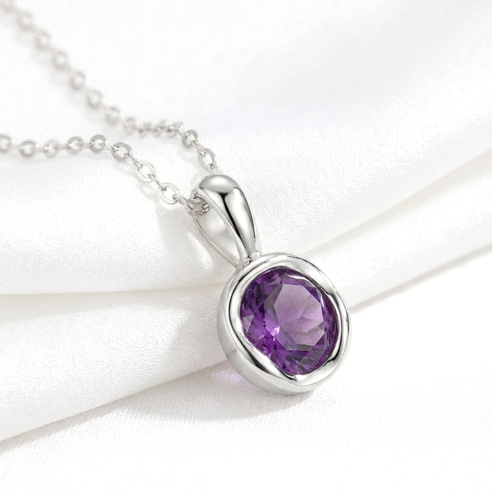 Macro view of the round cut deep royal purple simulated amethyst pendant and sterling silver chain.