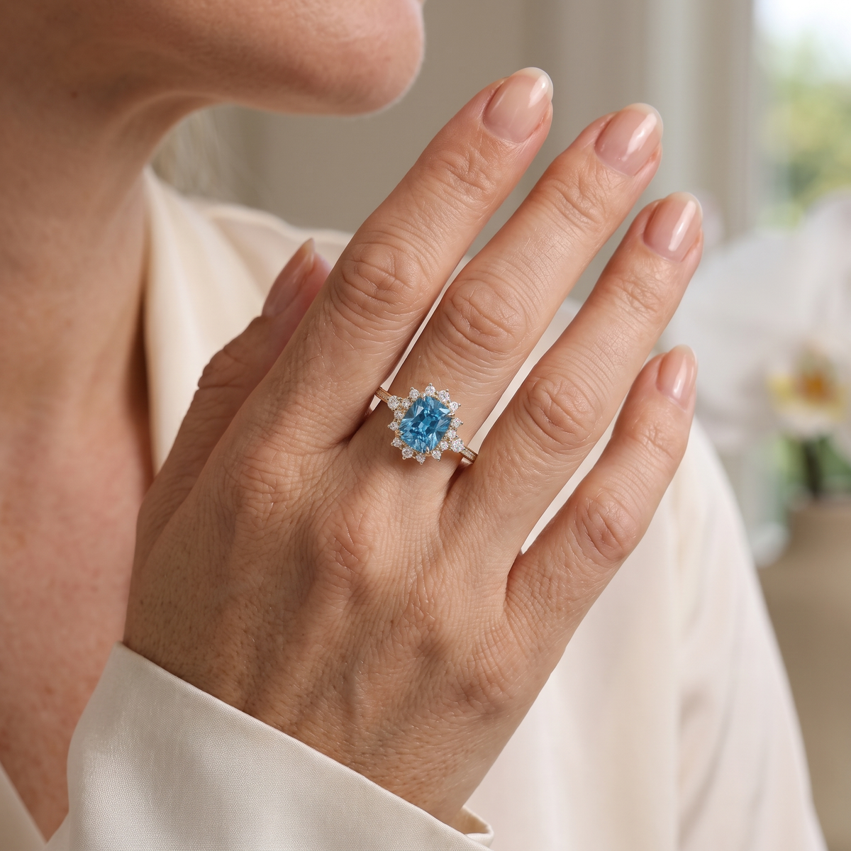 Yellow gold cushion-cut blue gemstone halo ring worn on a hand.
