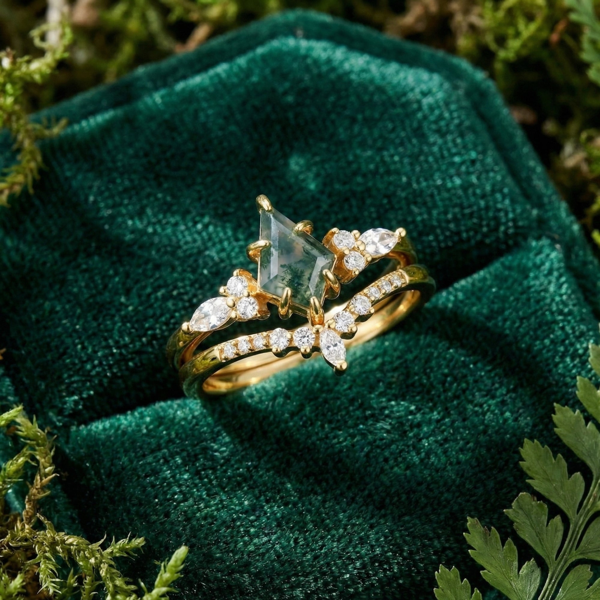Angled view of a kite-cut moss agate duo ring set in gold-plated sterling silver on a green velvet box.