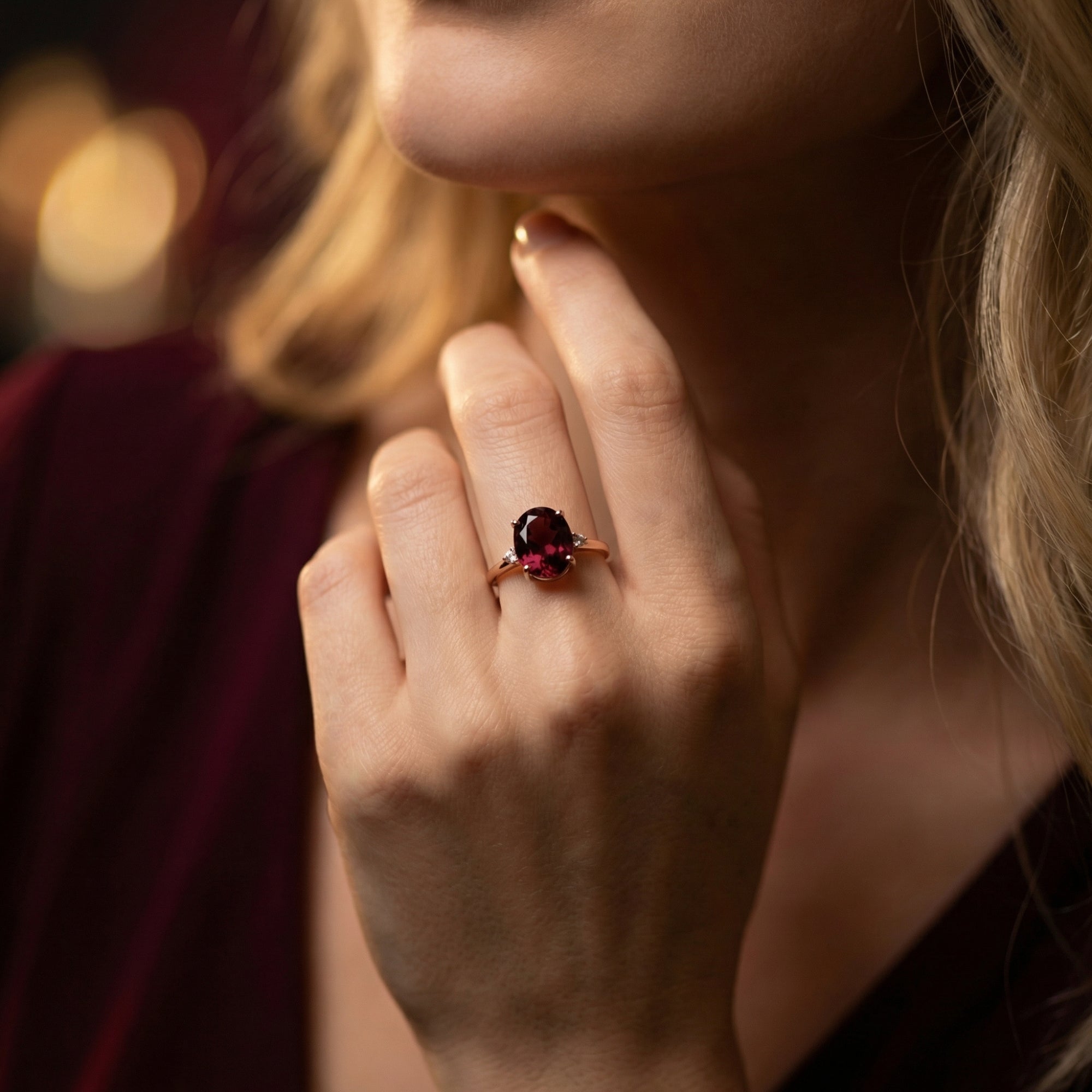 Model wearing the Solange 18K rose gold ring featuring a large 6ct oval natural garnet on her finger.
