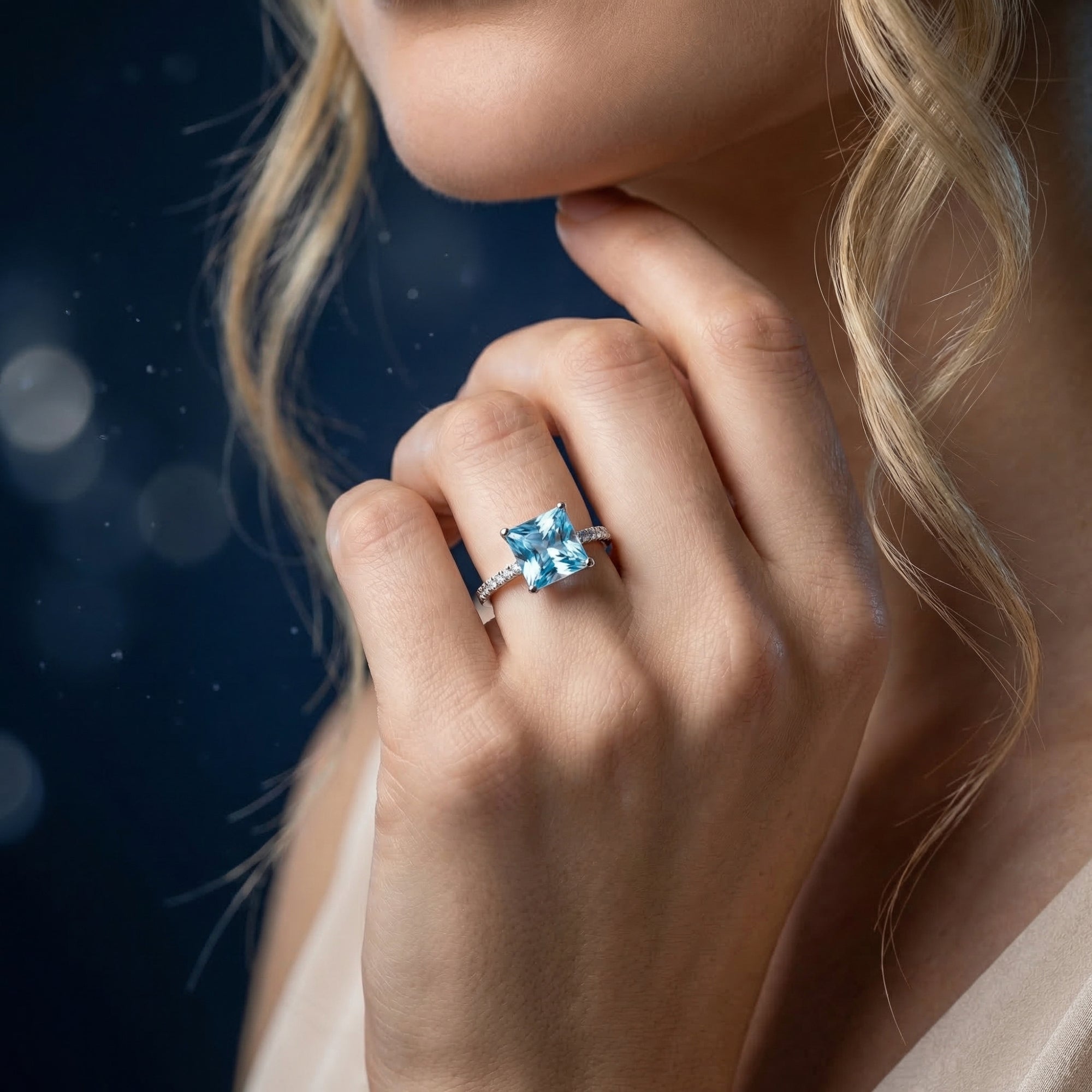 Model wearing the princess cut natural blue topaz ring in sterling silver on her ring finger.