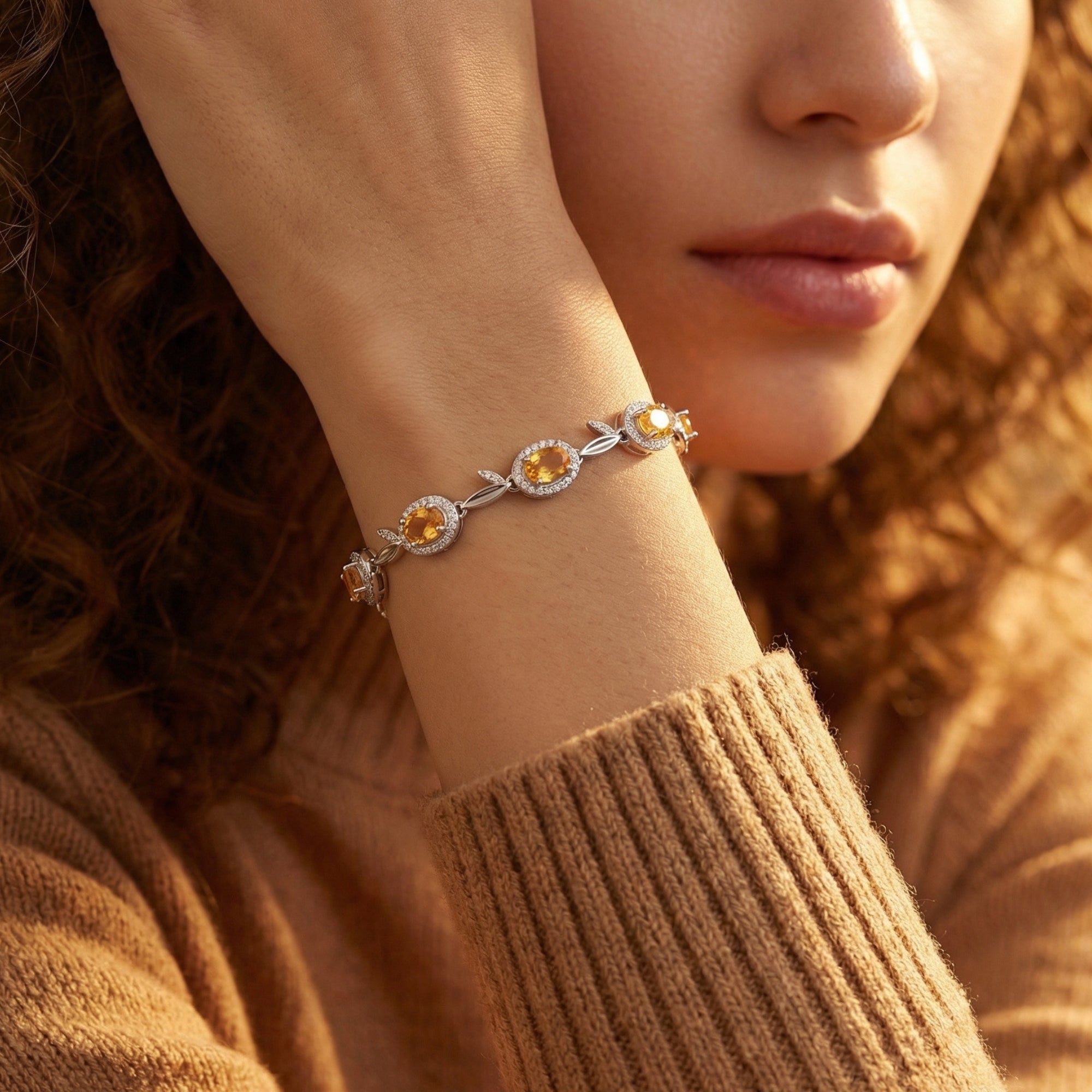 Model wearing the Sunniva natural citrine bracelet in silver on her wrist, featuring oval-cut stones and leaf accents.