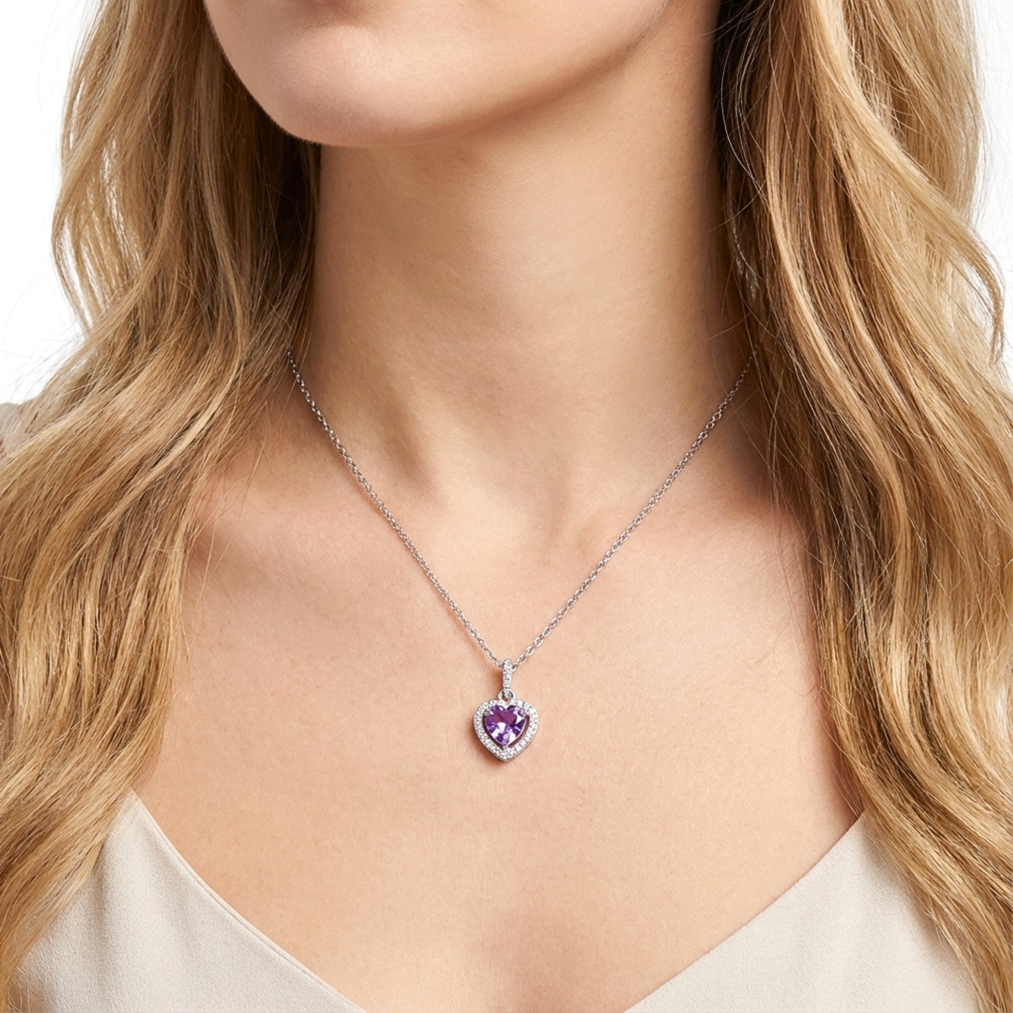Woman wearing the Calanthe Heart necklace with a purple simulated amethyst stone in sterling silver.