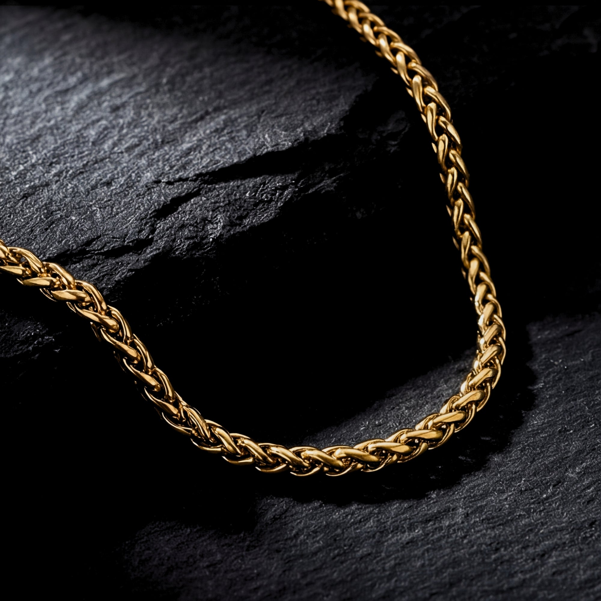 Close-up of the intricate links on a gold stainless steel wheat chain for men.