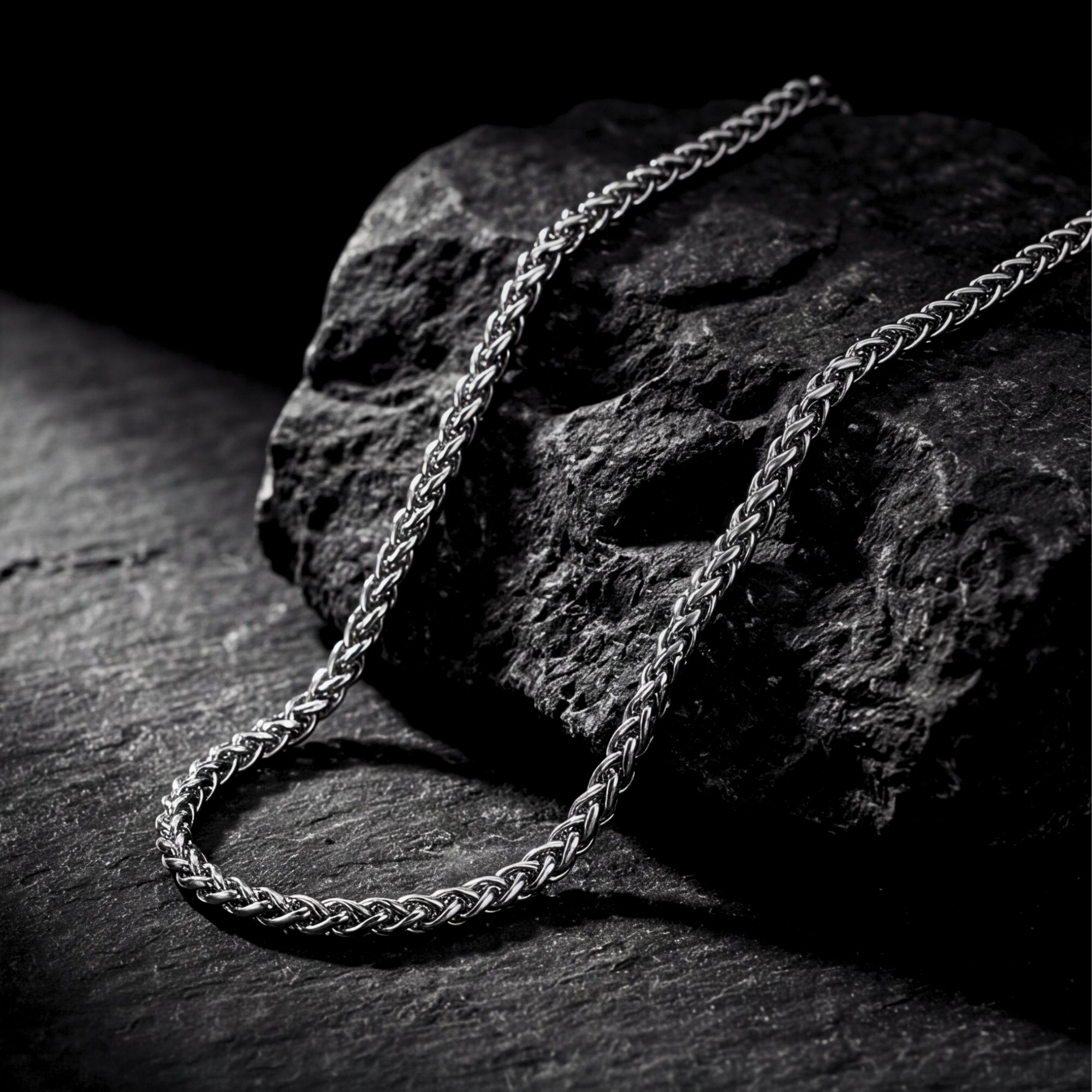 Detailed view of the intricate links on a silver stainless steel wheat weave chain.