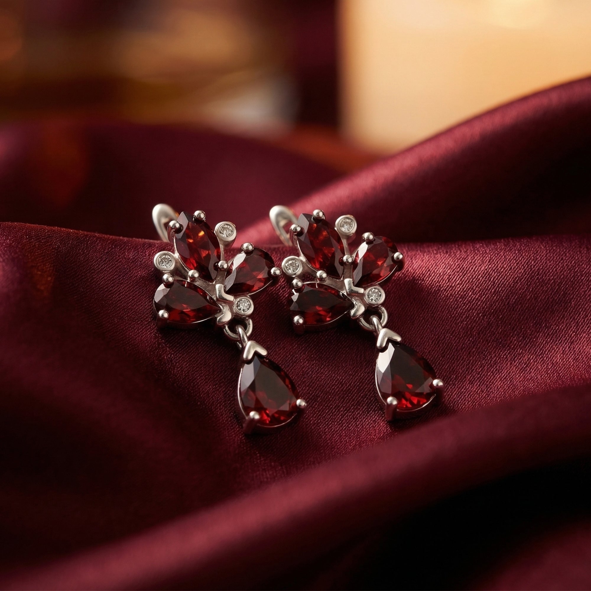 Macro shot of Fiamma cluster earrings showing the marquise and pear cut garnets in a silver setting.
