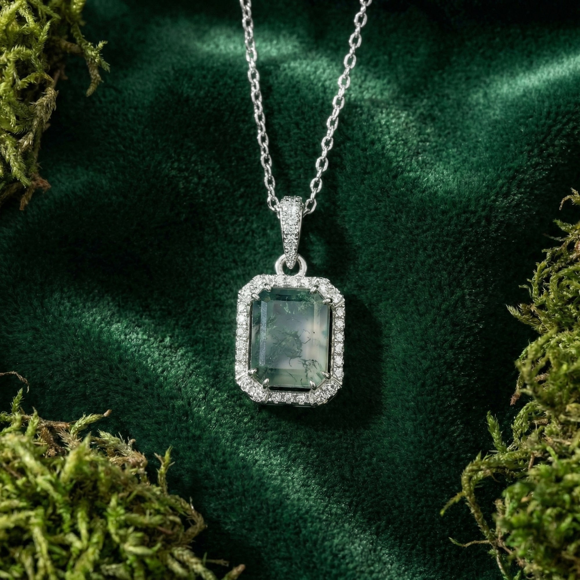 Close-up of a rectangular moss agate pendant with a gleaming halo border on a silver S925 sterling silver chain.