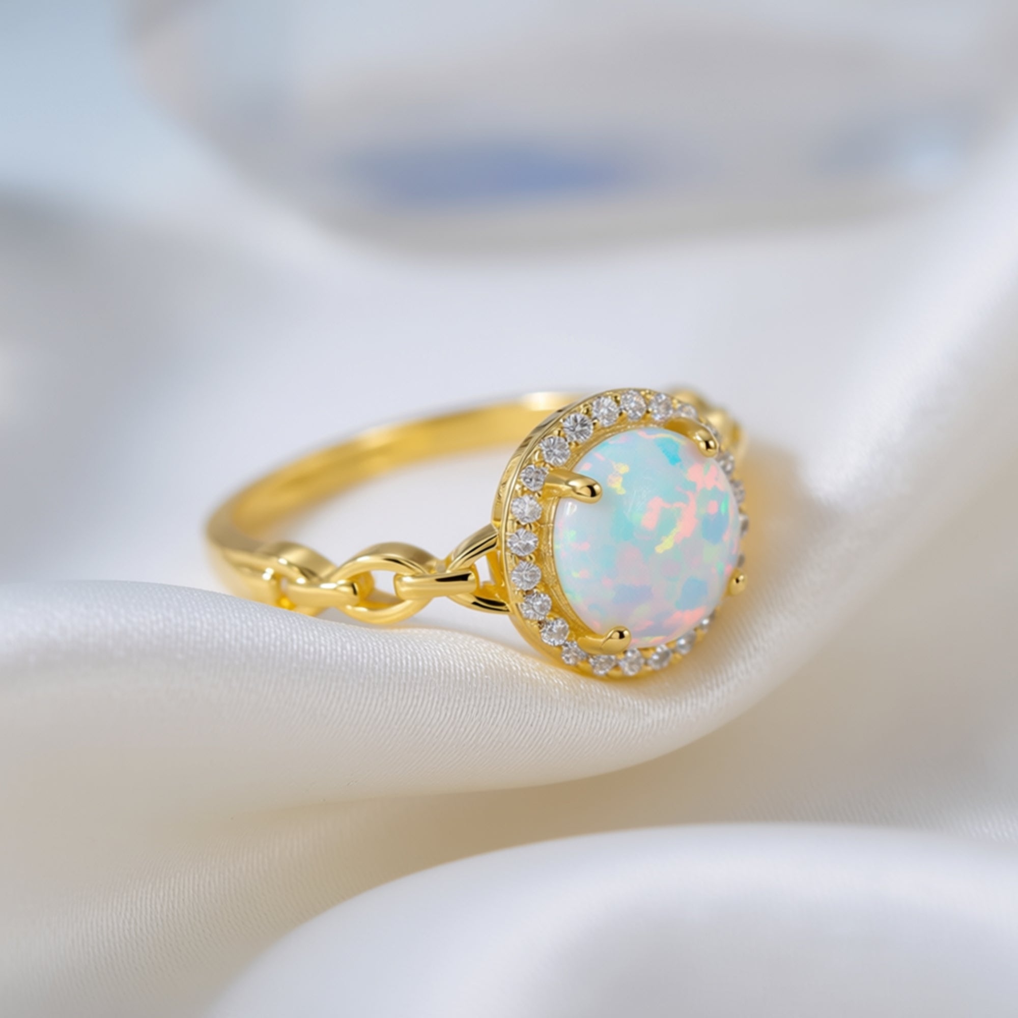 Close-up of the gold-tone S925 silver Aureoline ring showing the round white opal and decorative chain-link band.