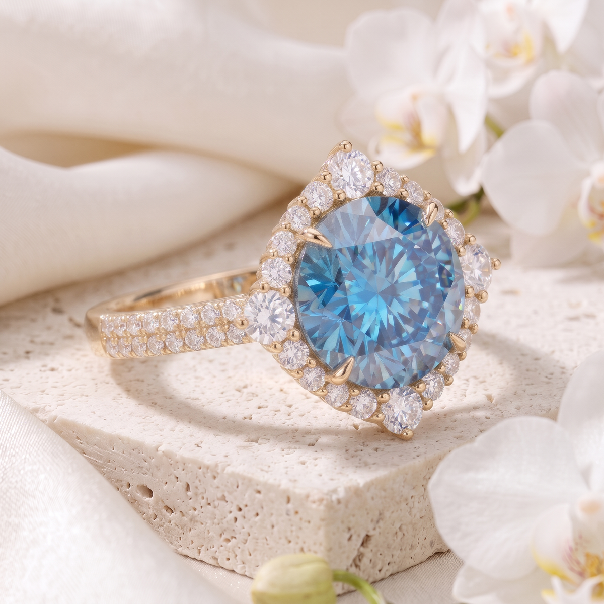 Side angle view of a round blue moissanite halo engagement ring in yellow gold on a stone display.