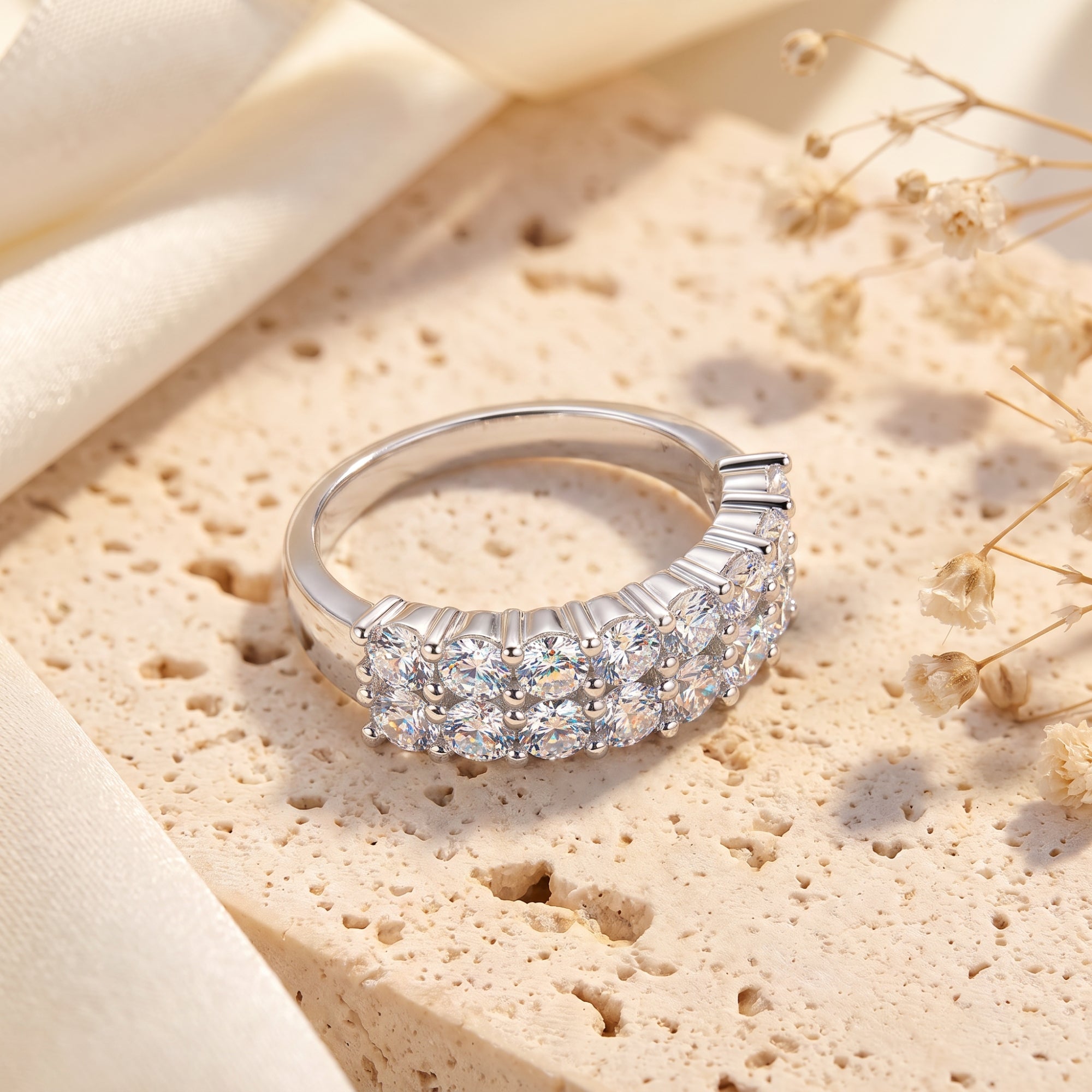Close-up of a three-row sterling silver band ring with round cubic zirconia stones.