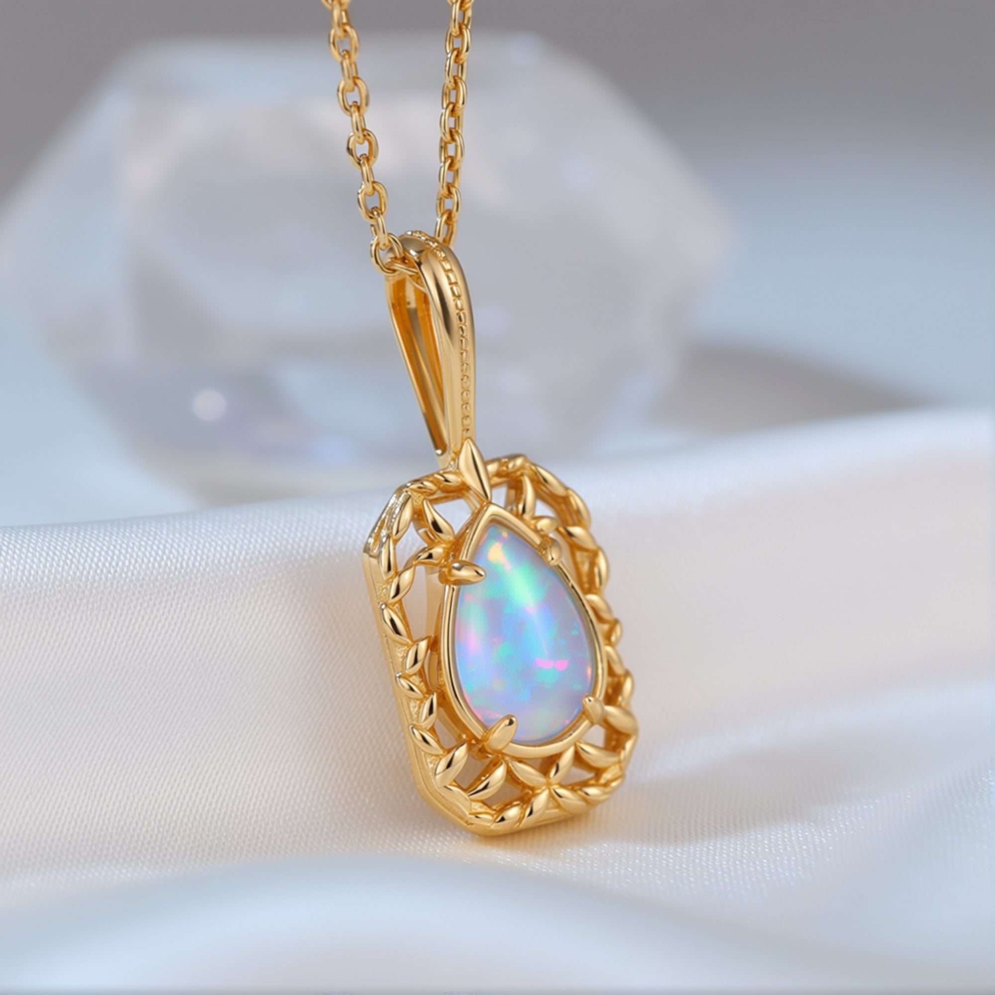 Angled macro shot of the pear-cut opal pendant showing the gold-finished filigree setting and play-of-color.