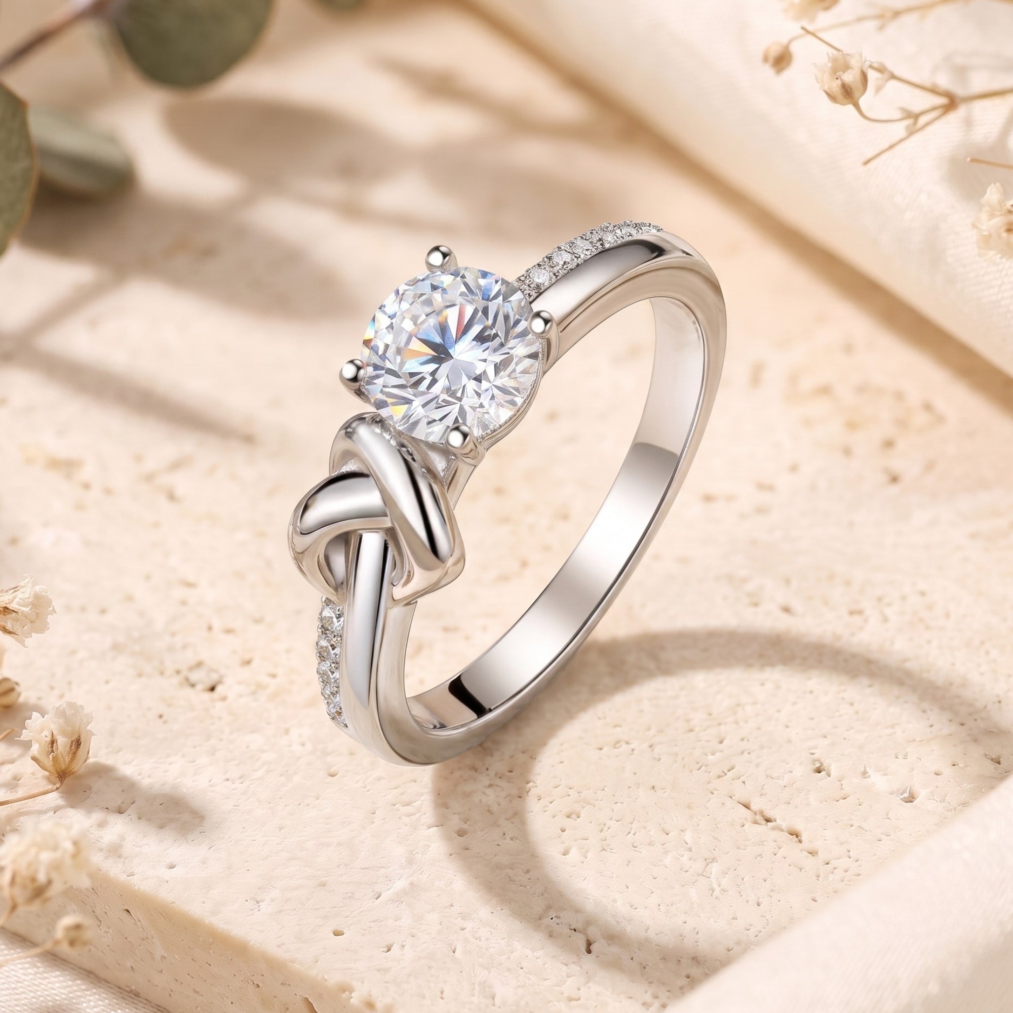Close-up of silver love knot ring featuring a round-cut cubic zirconia and pavé-set band.